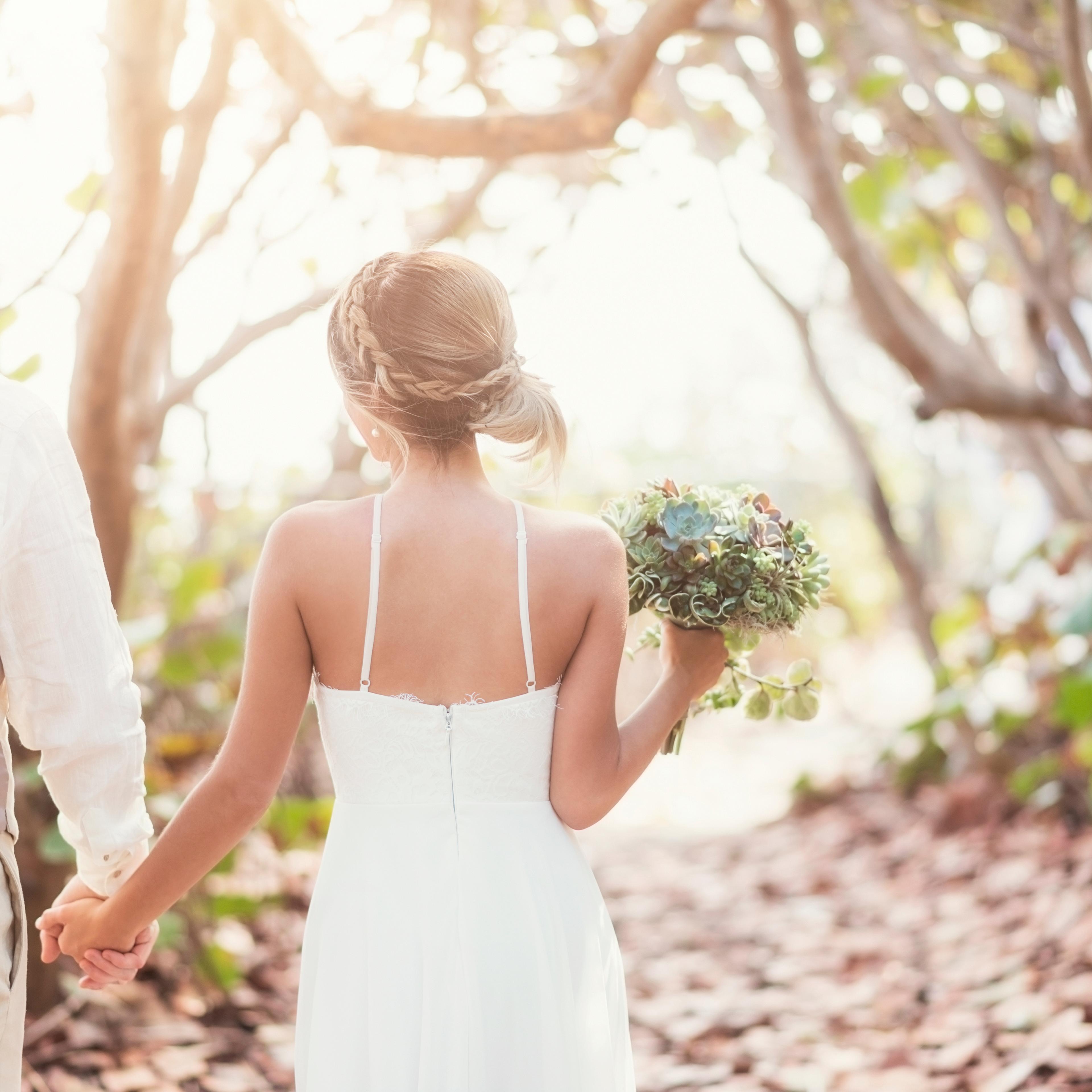 Bride and groom holding hands outdoors