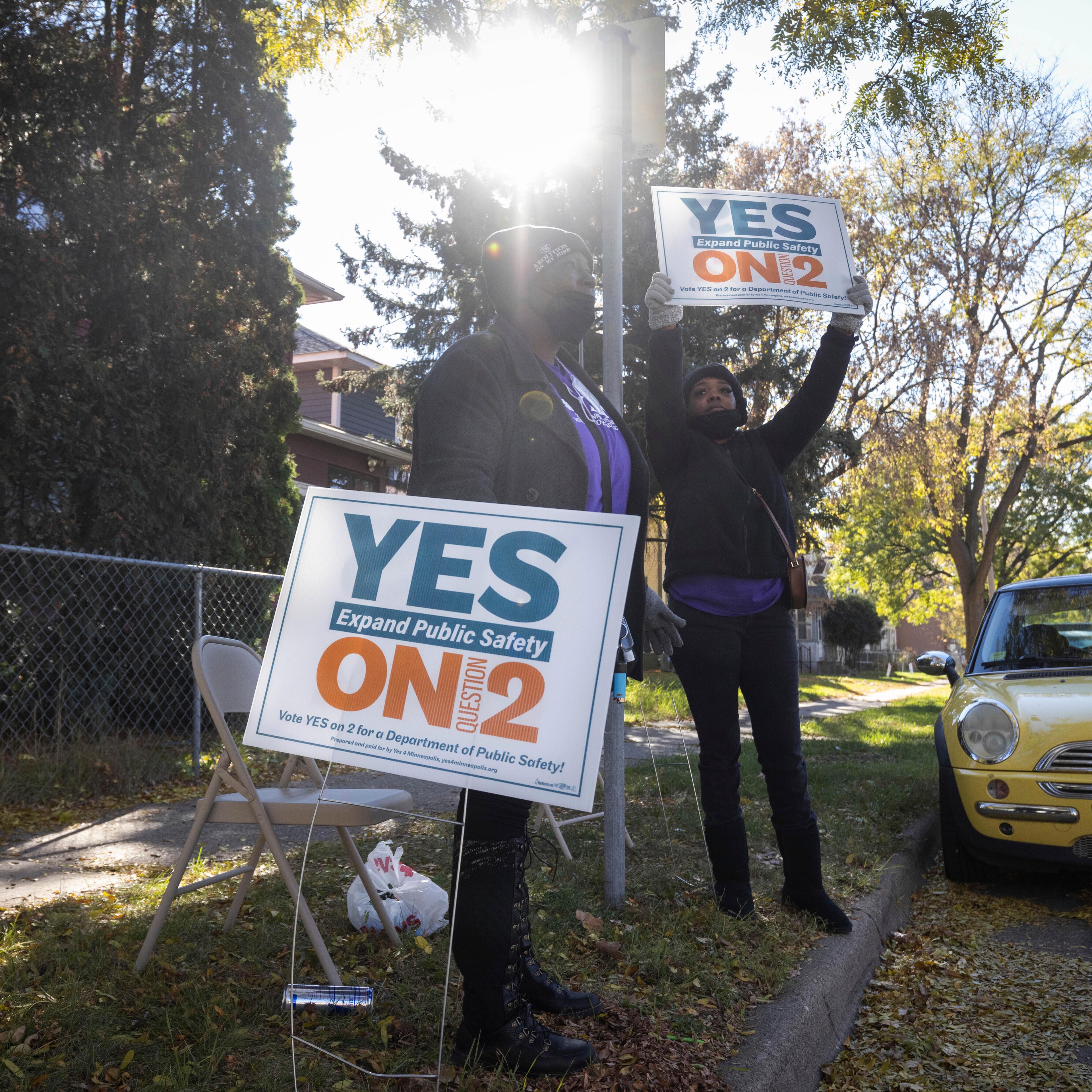 Volunteers urge community members to vote yes on ballot question two outside of a polling place on Tuesday, Nov. 2, 2021 in Minneapolis.