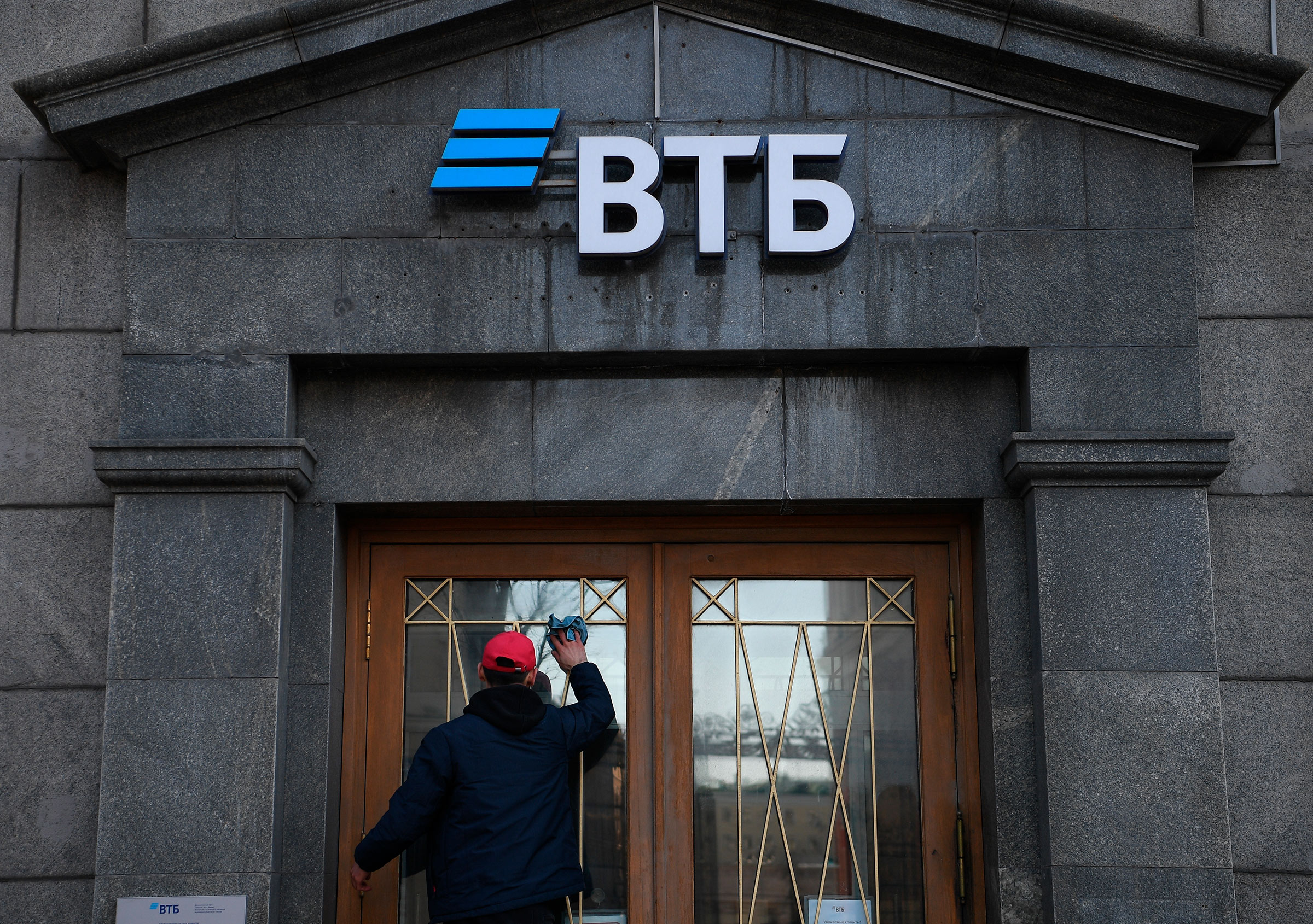 A worker cleans the doors of a branch of VTB bank in Moscow, Russia. On February 24 Russian President Vladimir Putin announced the start of the military operation in Ukraine, after which the Western countries toughened sanctions against Russia