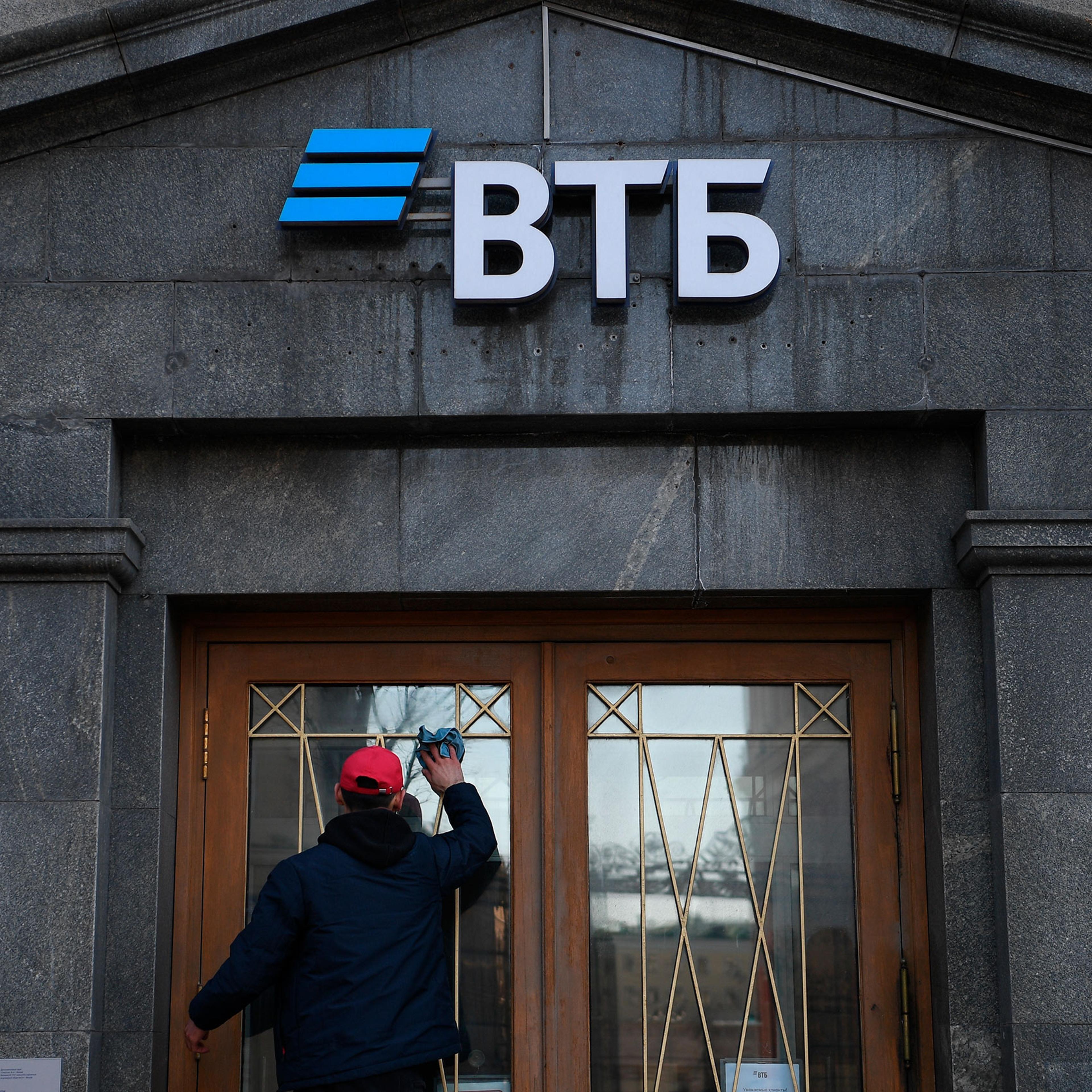 A worker cleans the doors of a branch of VTB bank in Moscow, Russia. On February 24 Russian President Vladimir Putin announced the start of the military operation in Ukraine, after which the Western countries toughened sanctions against Russia