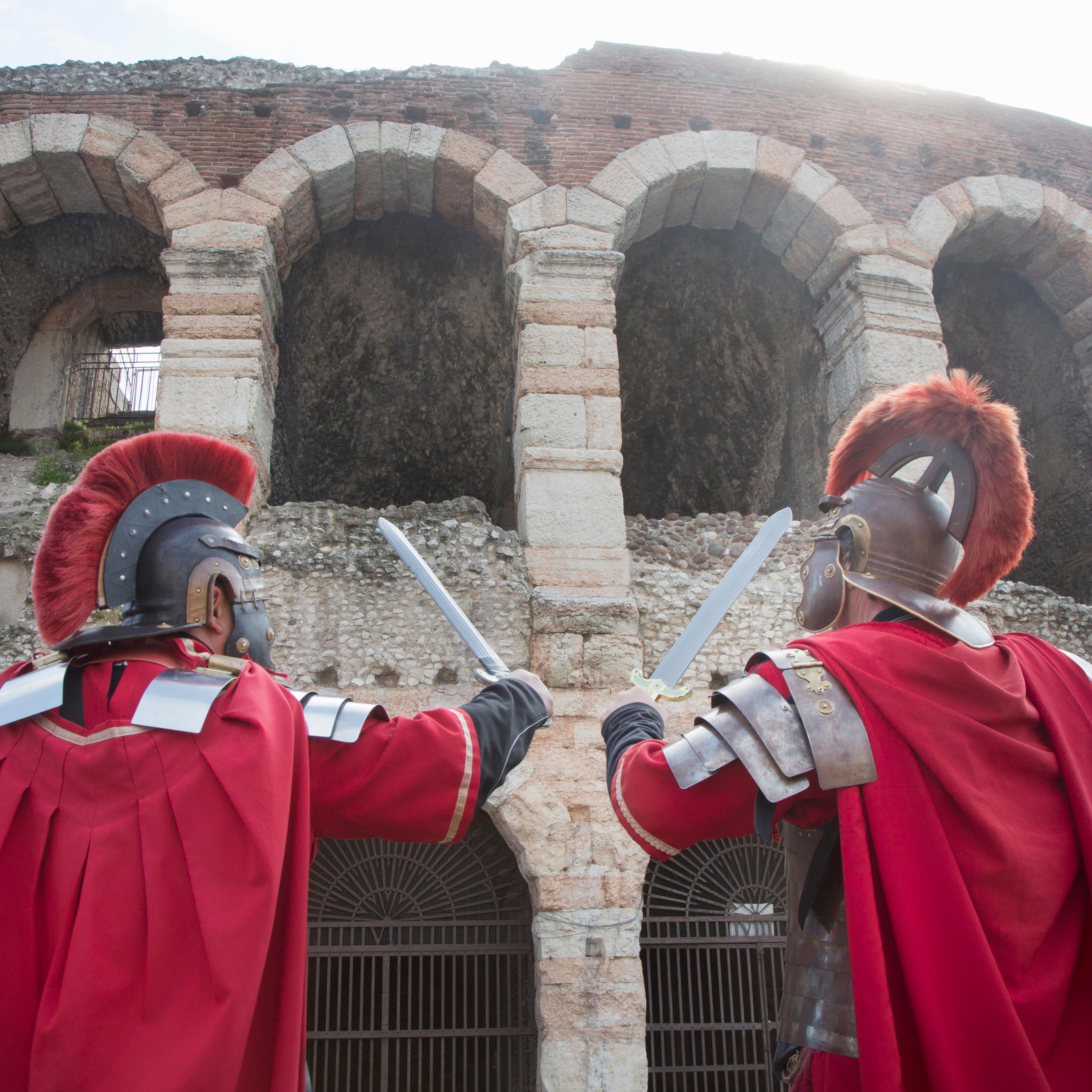 Two men dressed as Romans standing in front of the Coliseum