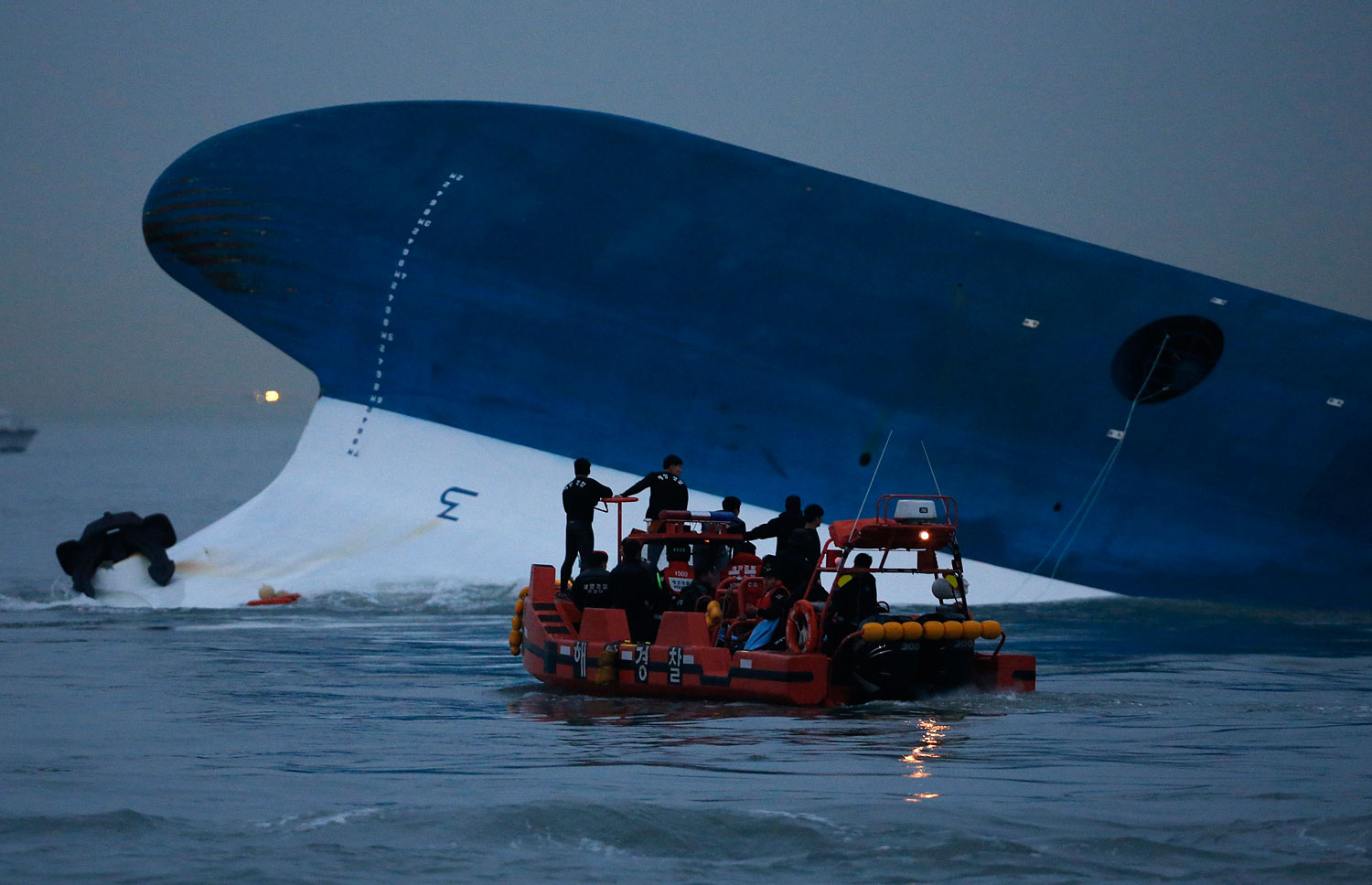 Maritime police search for missing passengers in front of the South Korean ferry "Sewol" which sank at the sea off Jindo April 16, 2014.