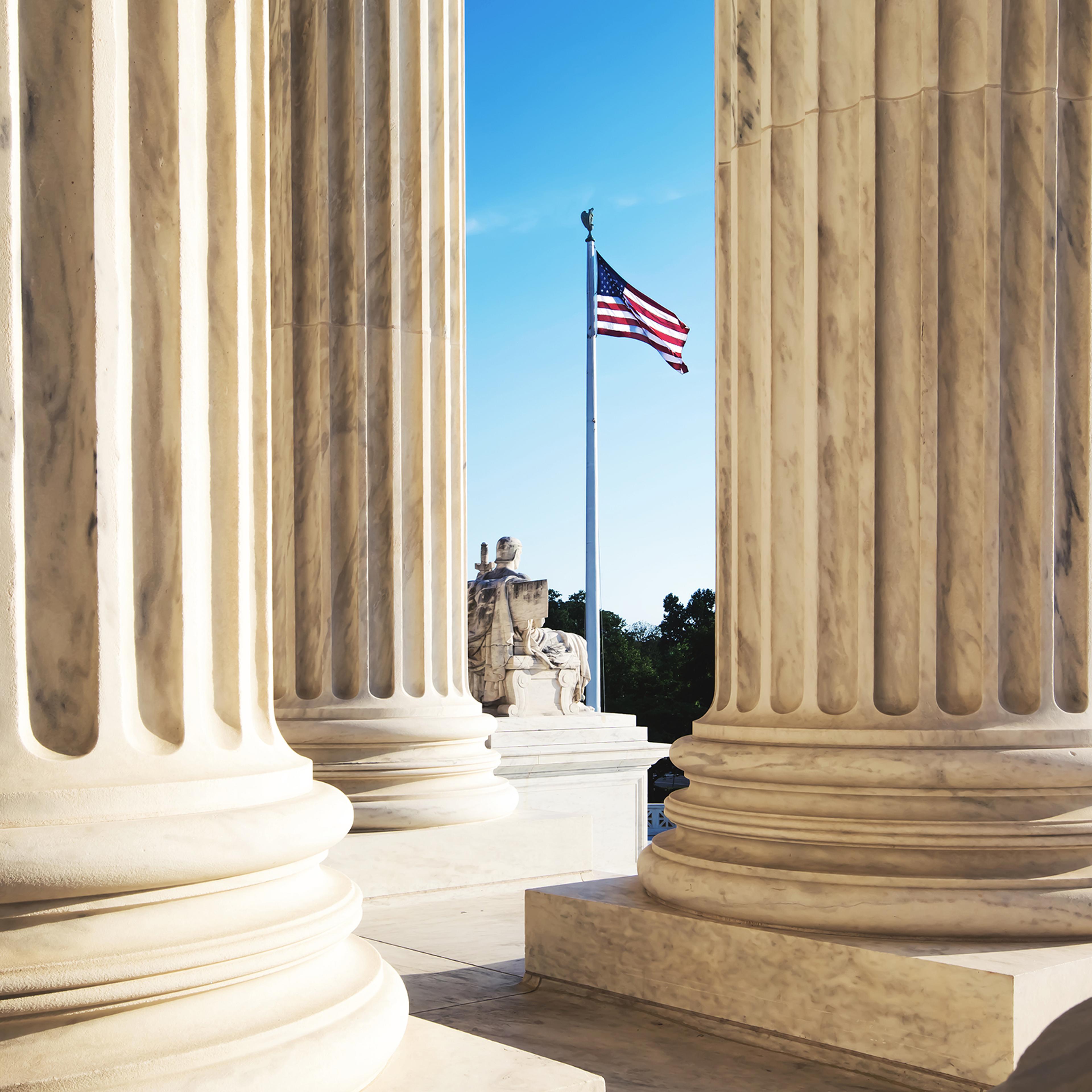 American Flag Seen Through Columns