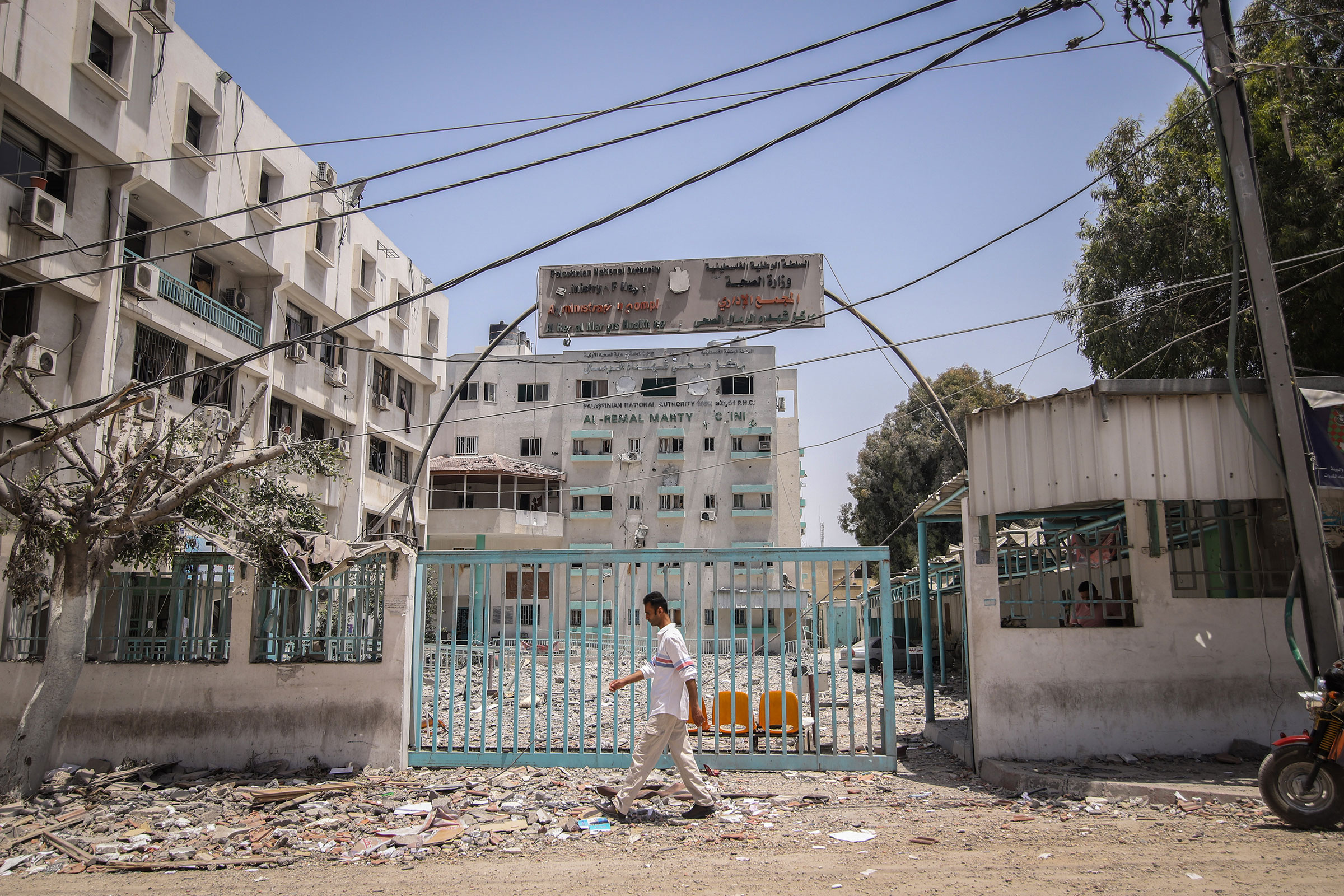 A pedestrian passes in front of the Al-Remal Clinic, Gaza's sole Covid-19 testing laboratory, damaged following Israeli airstrikes, in Gaza City, Gaza, on May 21, 2021.