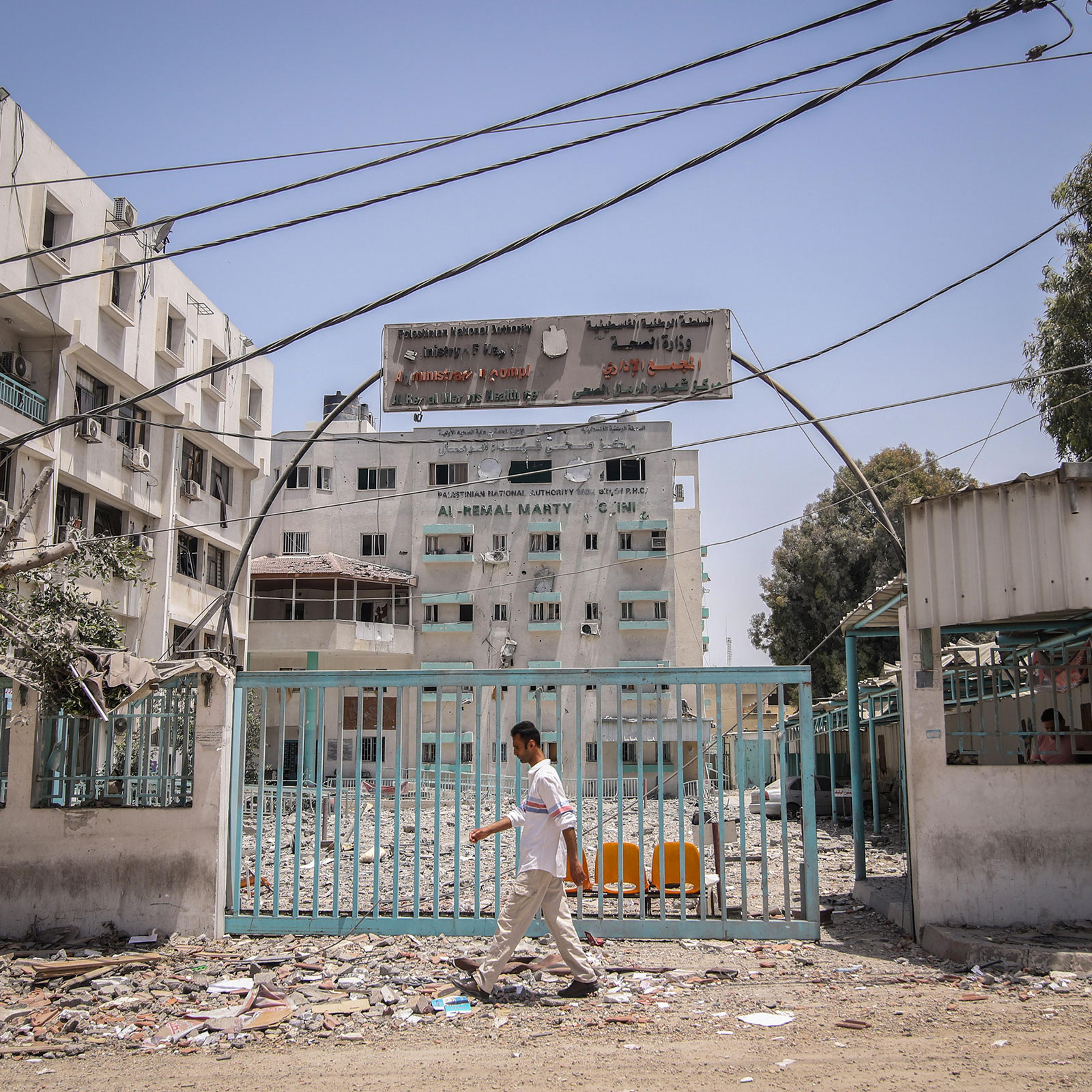 A pedestrian passes in front of the Al-Remal Clinic, Gaza's sole Covid-19 testing laboratory, damaged following Israeli airstrikes, in Gaza City, Gaza, on May 21, 2021.
