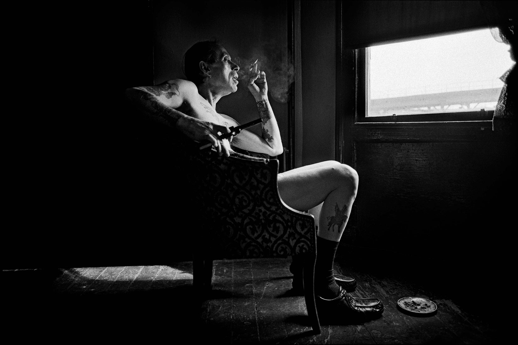 The Sol Mednick Gallery, Pa.: Sept. 30 - Oct. 28   (Caption: Uncle Charlie contemplating in his living room the reality that his son Joe is dying from HIV, sitting by the window holding his newest and latest handgun in his apartment in Bushwick, Brooklyn in 1996)
