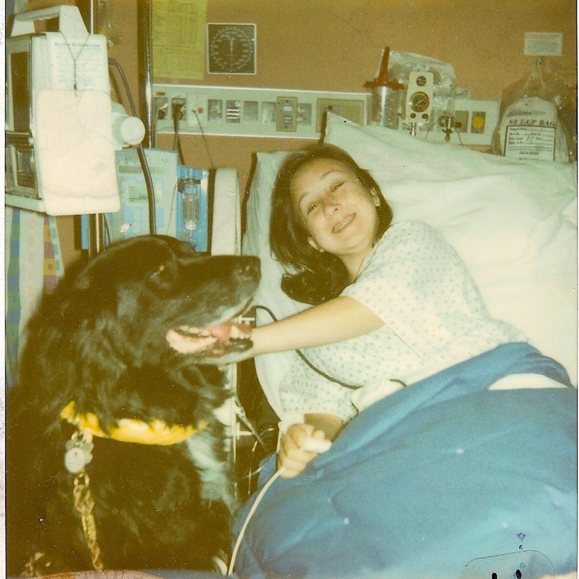 The author, at 14 years old, visited in the hospital by a therapy dog.