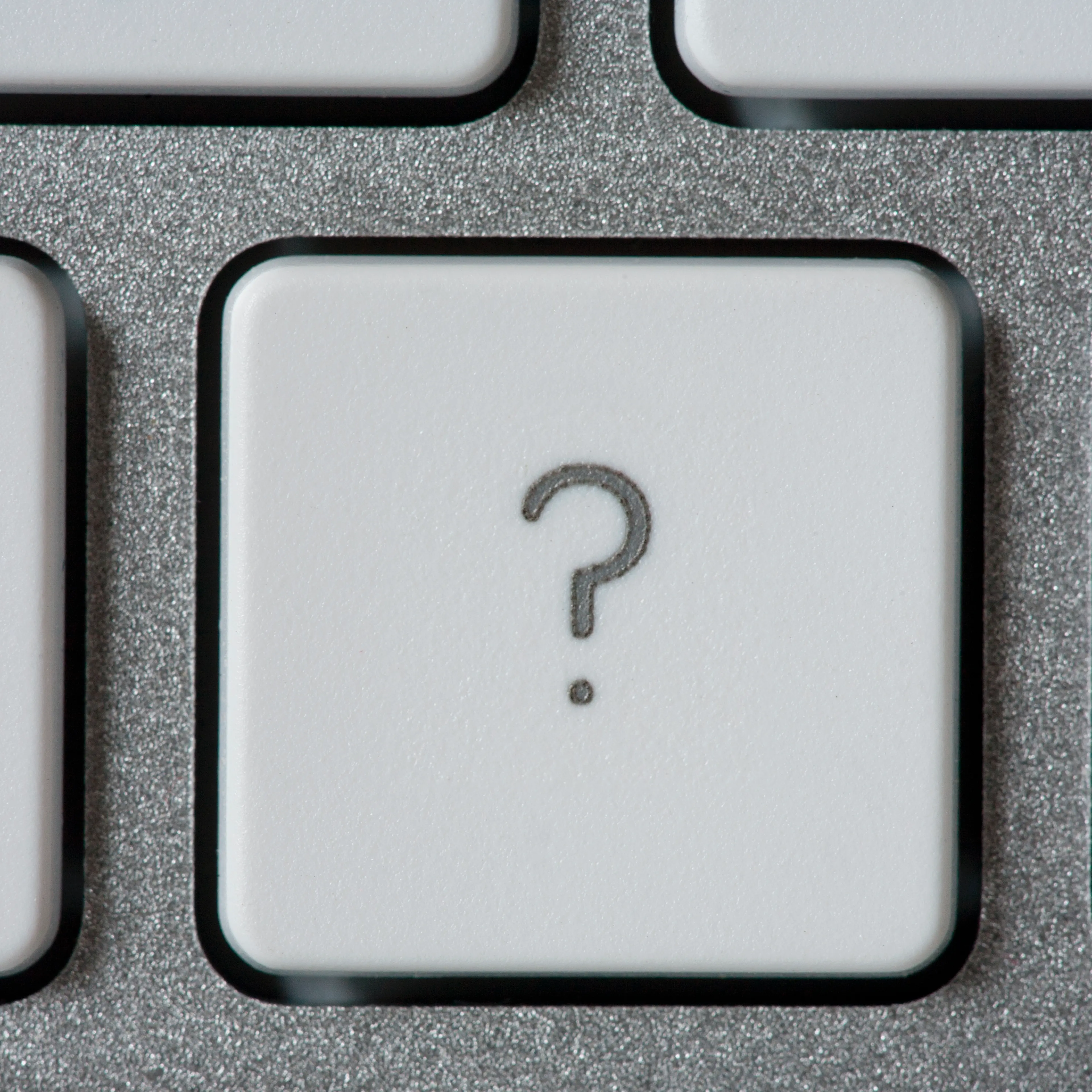 Computer keyboard with a key with a question mark.