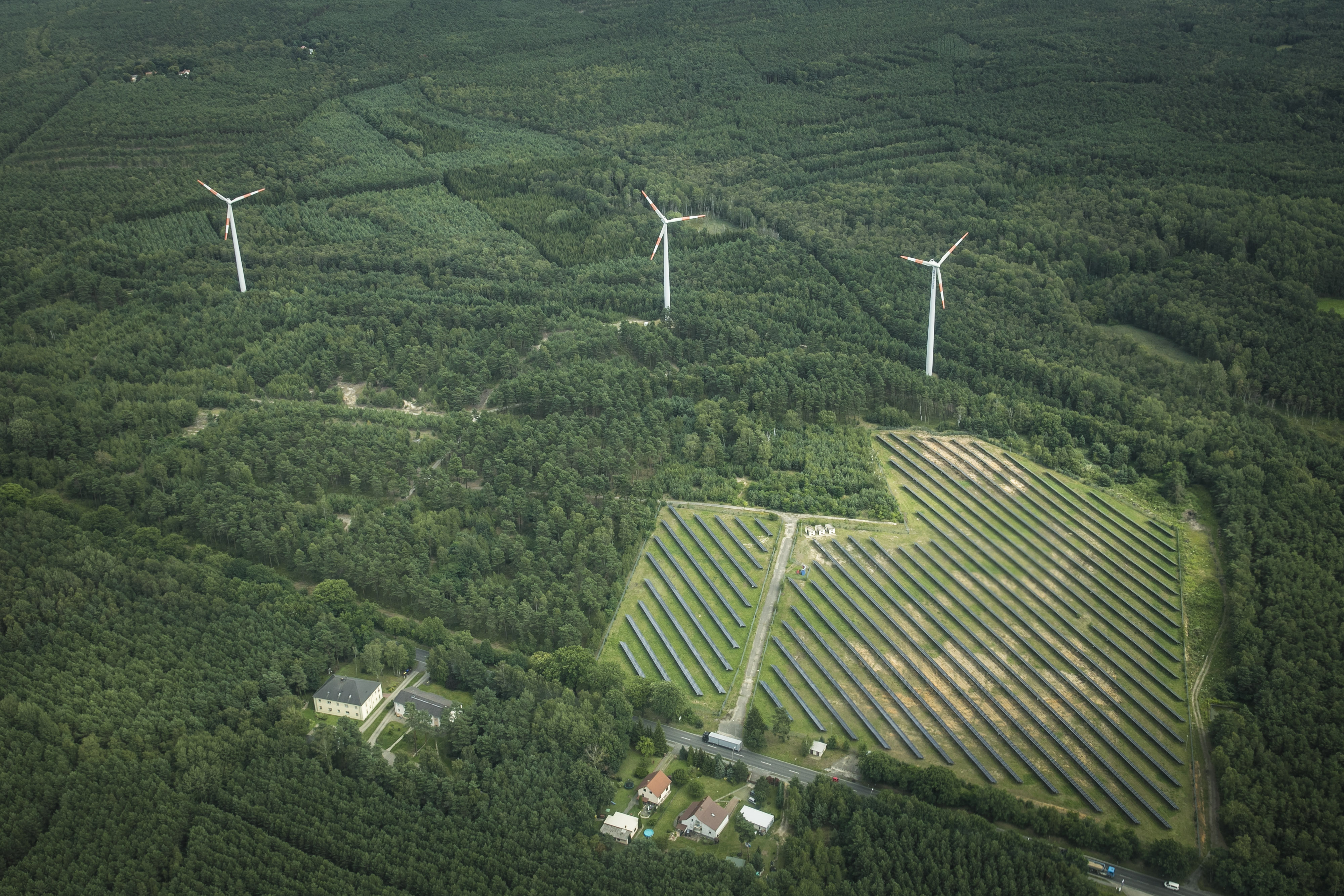 This aerial photo shows wind power stations next to a solar fields on Aug. 04, 2017 in Bernsdorf, Germany.