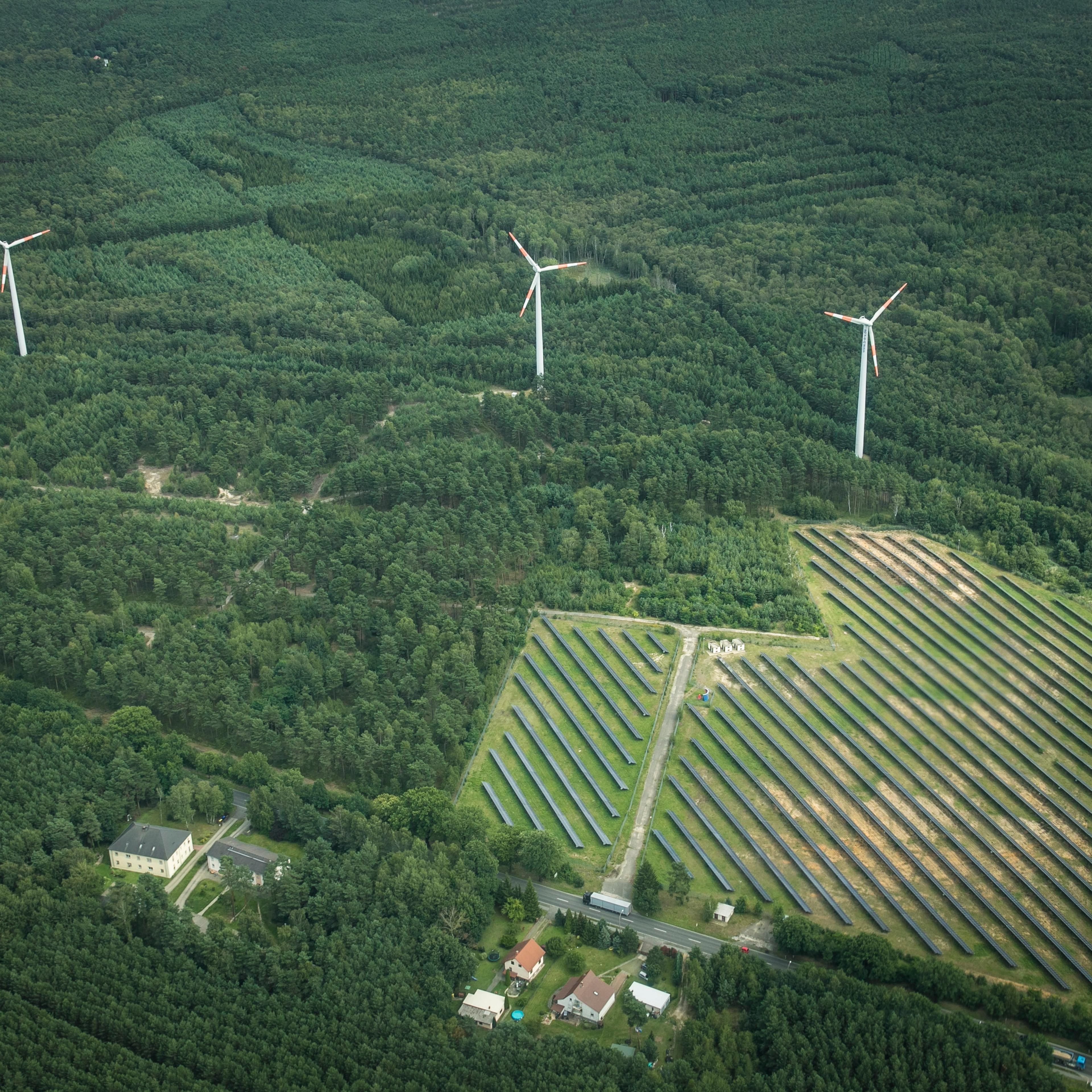 This aerial photo shows wind power stations next to a solar fields on Aug. 04, 2017 in Bernsdorf, Germany.