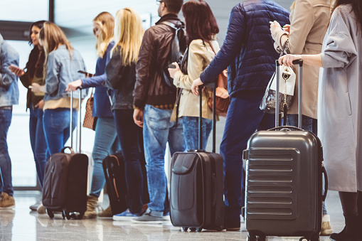 Group of people standing in queue to board airplane