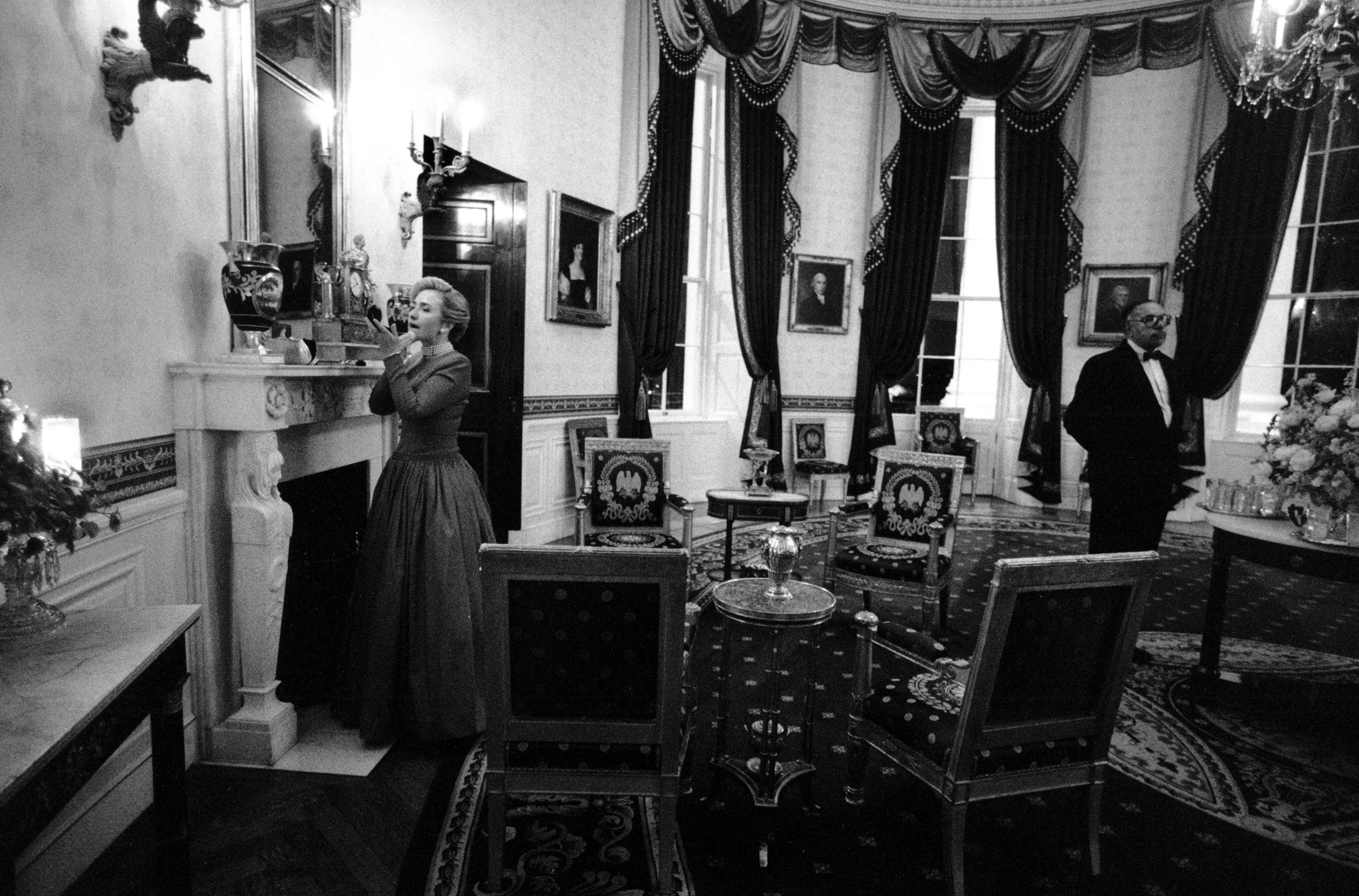 Hillary Clinton does a last-minute touchup in the Blue Room before the 1996 National Governors Association dinner as longtime butler James Jeffries stands nearby, Feb. 4, 1996. 