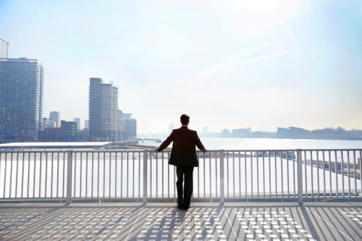 businessman-looking-out-city