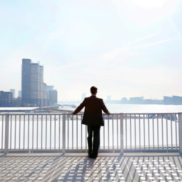 businessman-looking-out-city