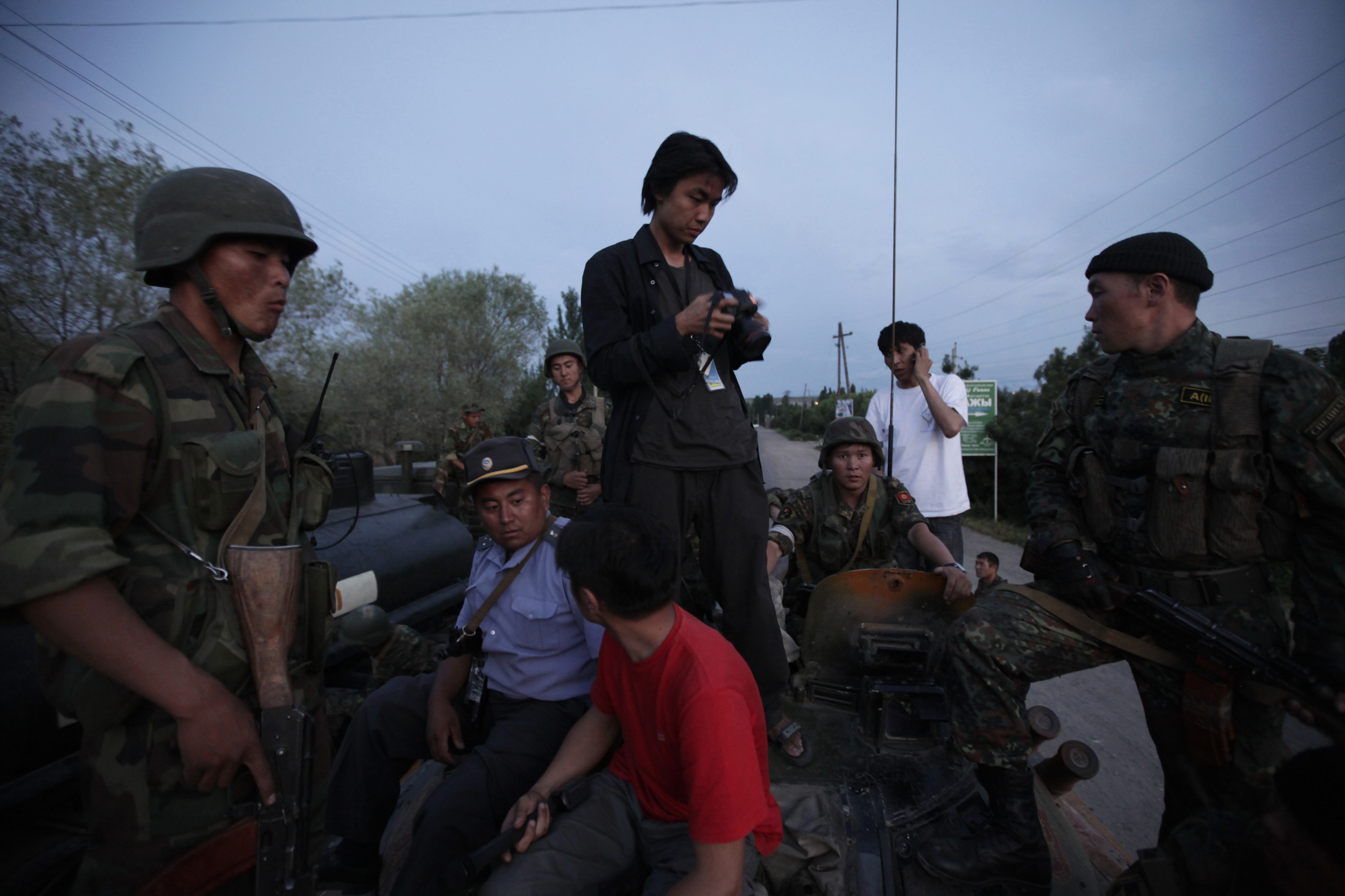Ed Ou stands atop a Kyrgyz military tank while covering a flareup of violence after ethnic Kyrgyz mobs rampaged through minority Uzbek enclaves, burning homes and businesses in Osh, Kyrgyzstan.