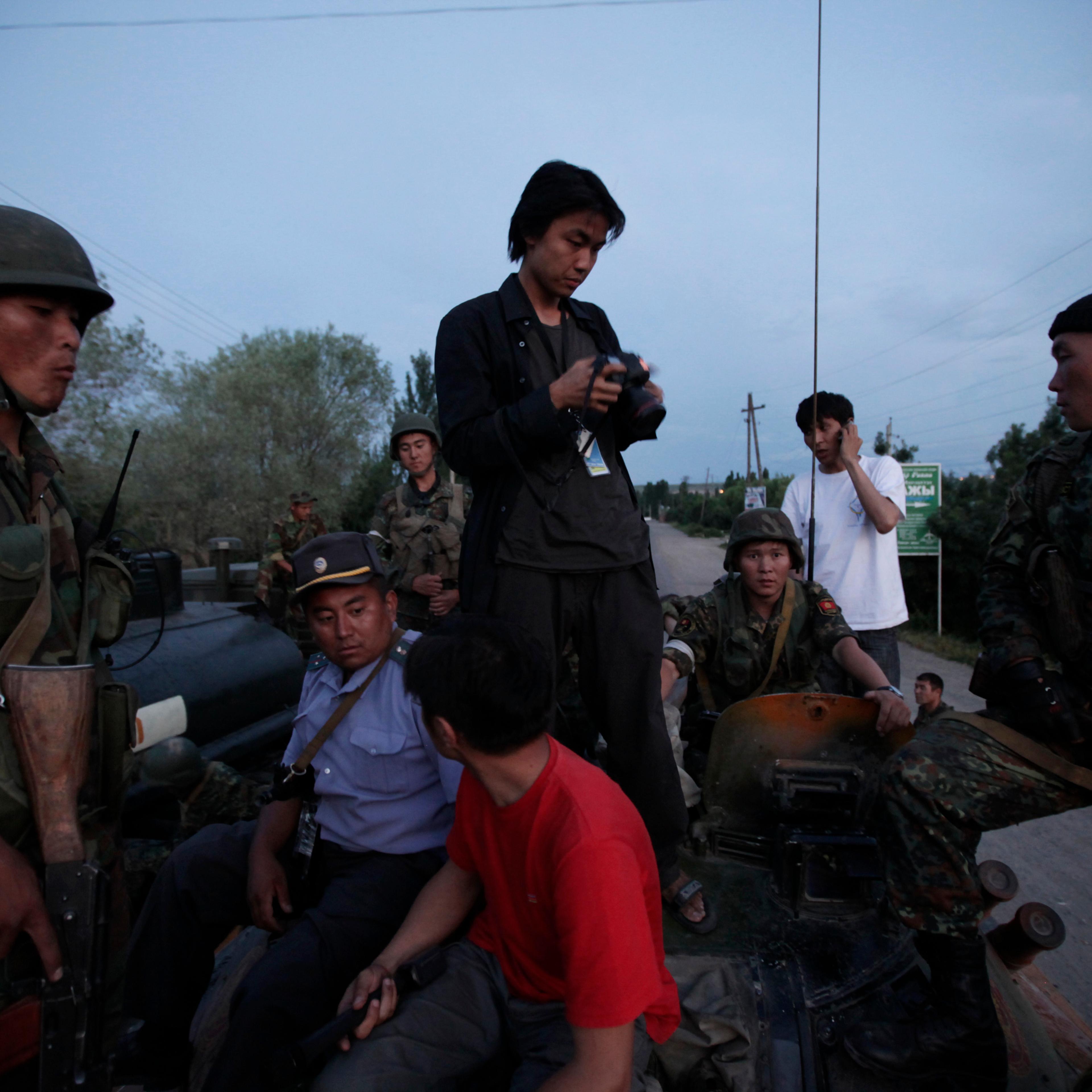 Ed Ou stands atop a Kyrgyz military tank while covering a flareup of violence after ethnic Kyrgyz mobs rampaged through minority Uzbek enclaves, burning homes and businesses in Osh, Kyrgyzstan.