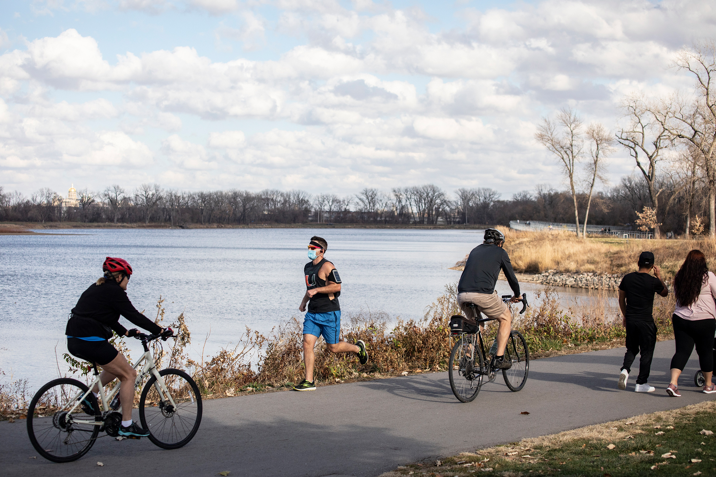 A jogger wears a face mask while running around Gray's Lake in Des Moines on Nov. 8, 2020