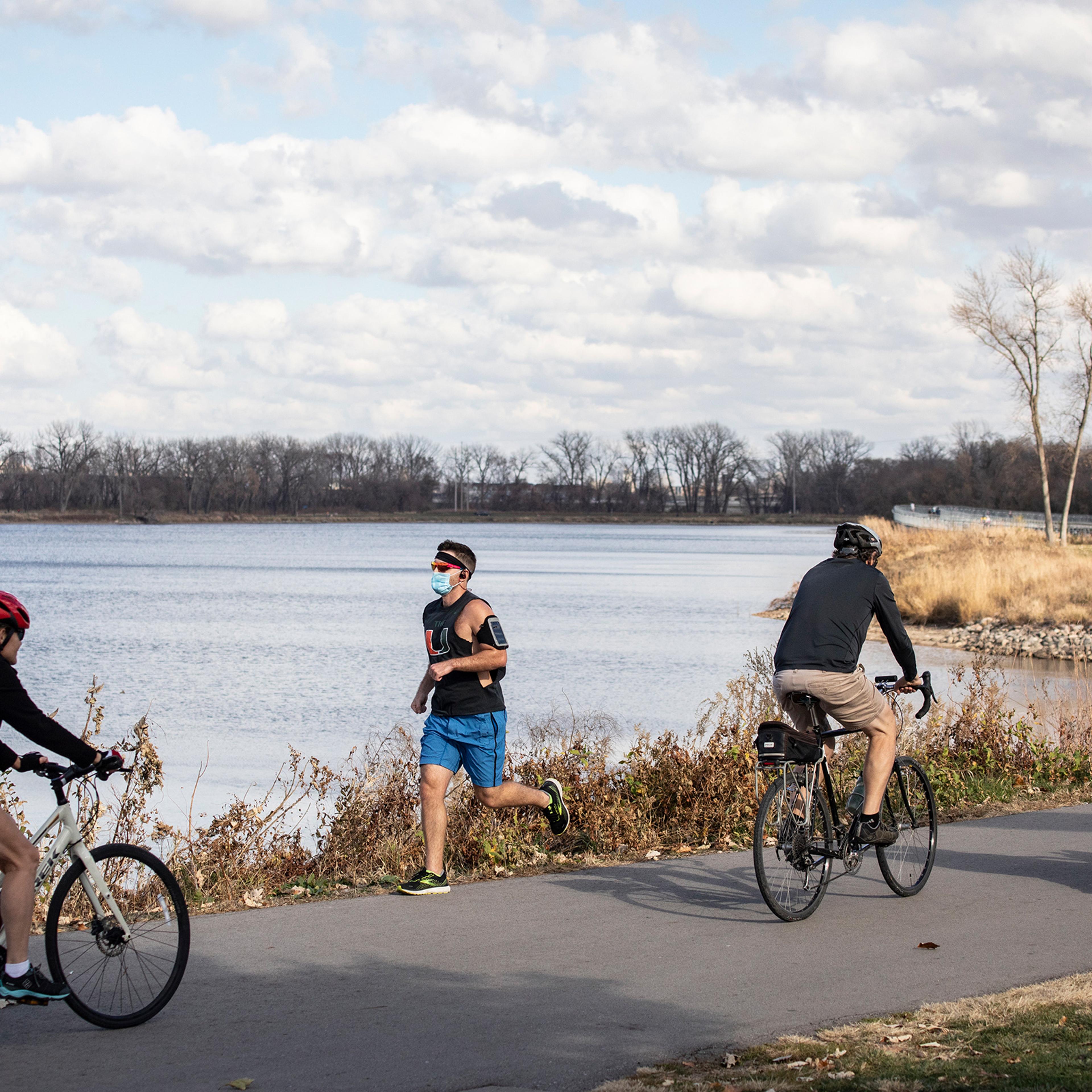 A jogger wears a face mask while running around Gray's Lake in Des Moines on Nov. 8, 2020