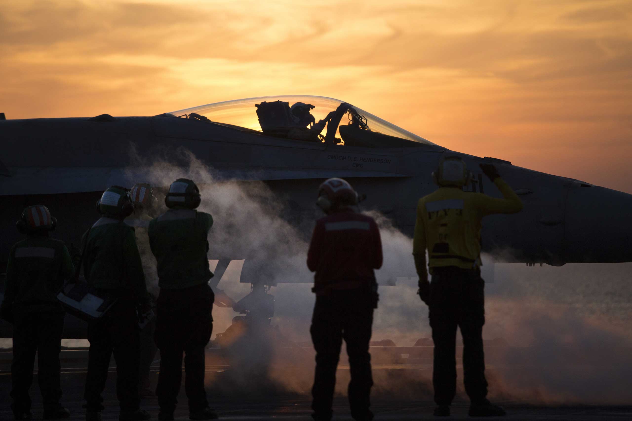 Crew members around an aircraft aboard the USS Carl Vinson, a Nimitz-class aircraft carrier, in the Persian Gulf, Dec. 8, 2014.
