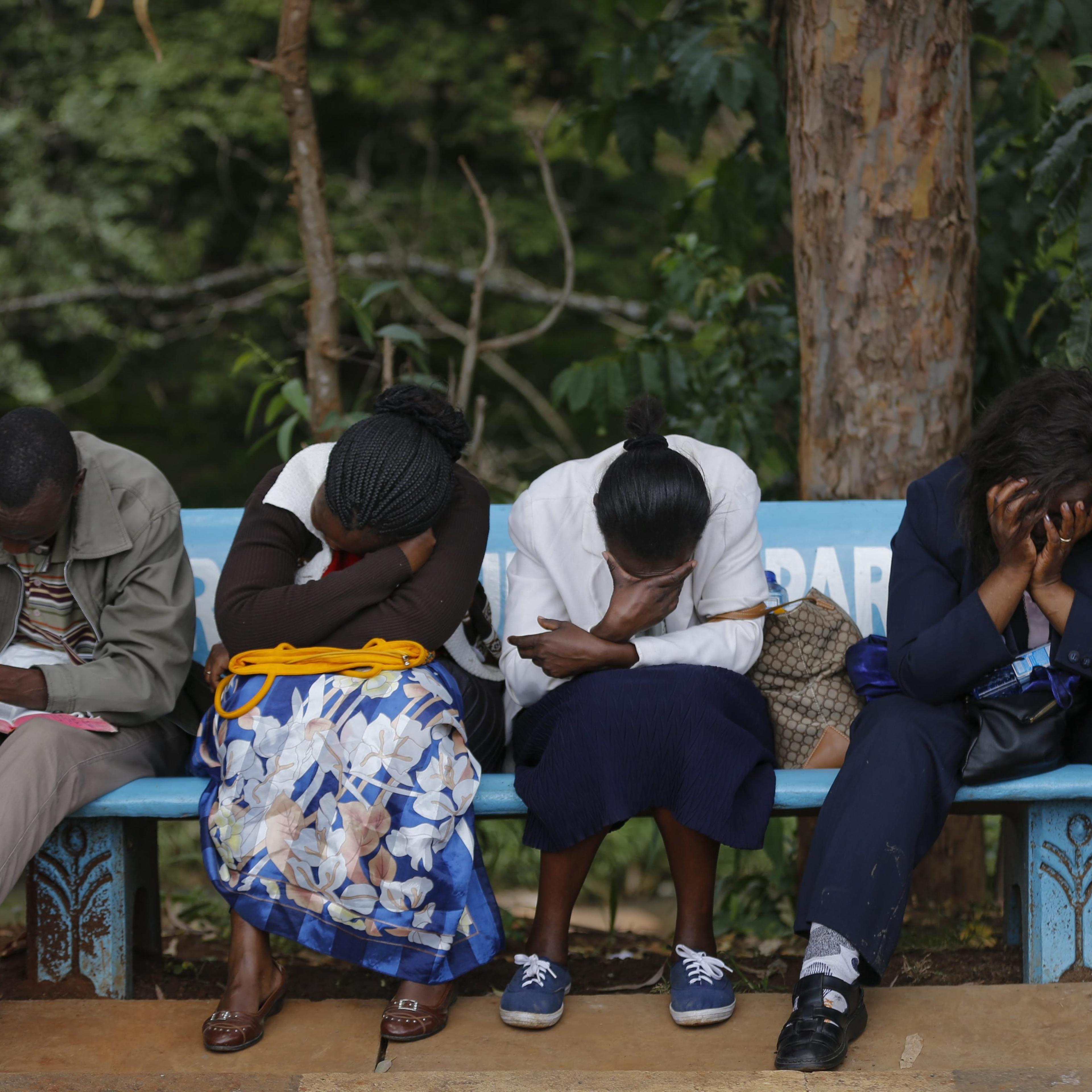 Family members sit on a bench as they wait to view the bodies of their loved ones who had been killed in an attack on Garissa University College, at a mortuary in Nairobi on April 8, 2015.