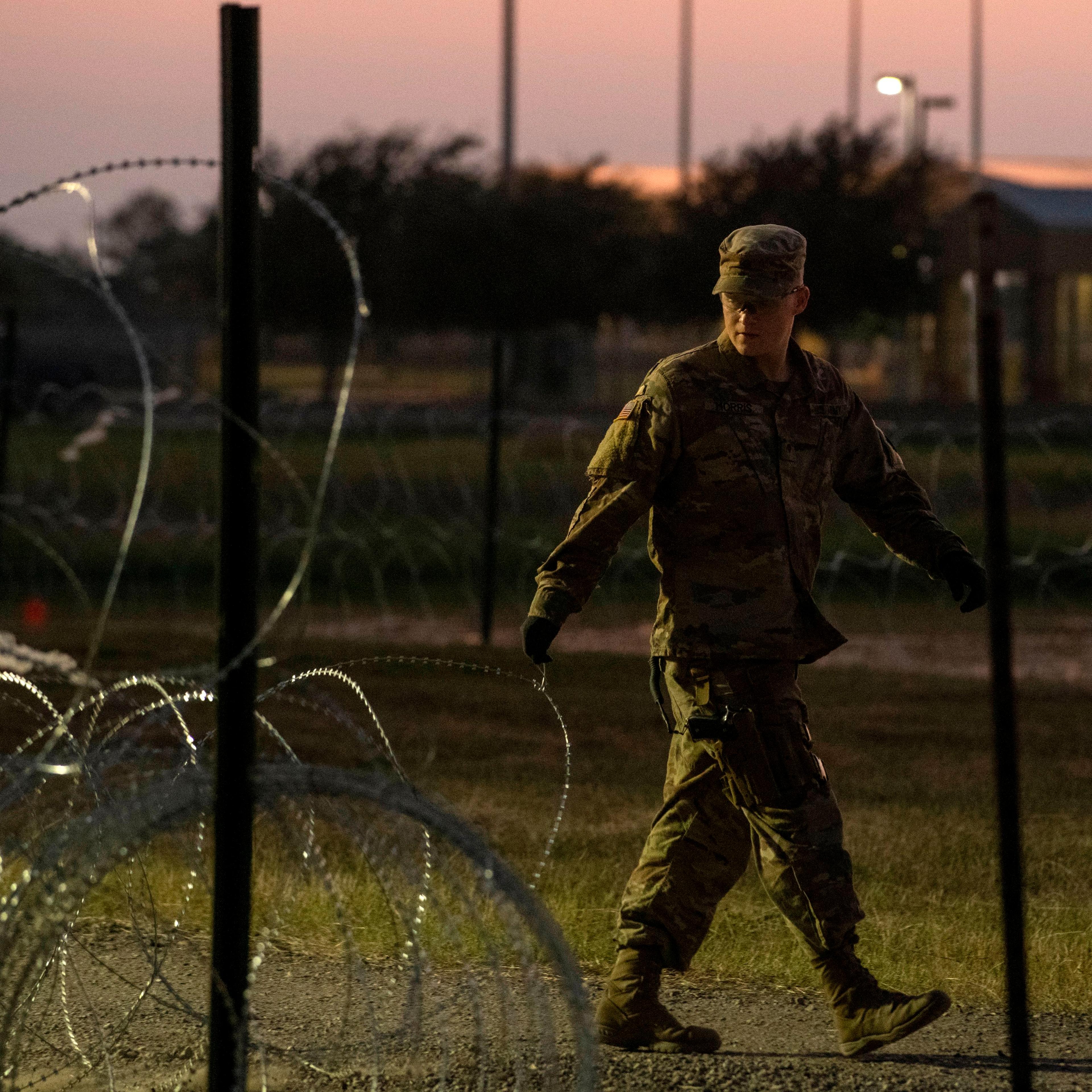 A US Army soldier closes a razor-wire gate at a compound where the military is erecting an encampment near the US-Mexico border crossing at Donna, Texas, on November 6, 2018.