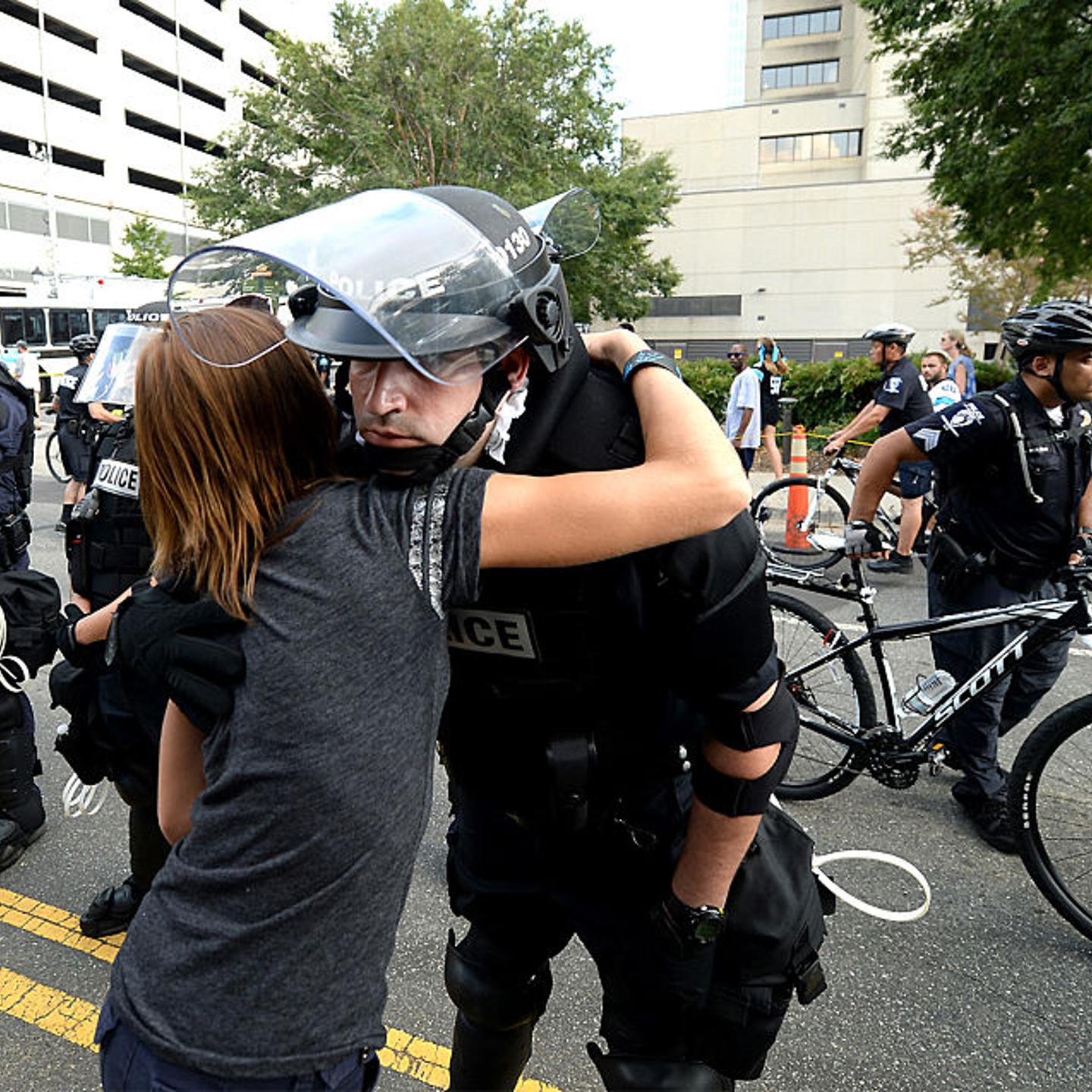 A woman hugs a police officer outside Bank of America Stadium on Sept. 25, 2016 in Charlotte, N.C.