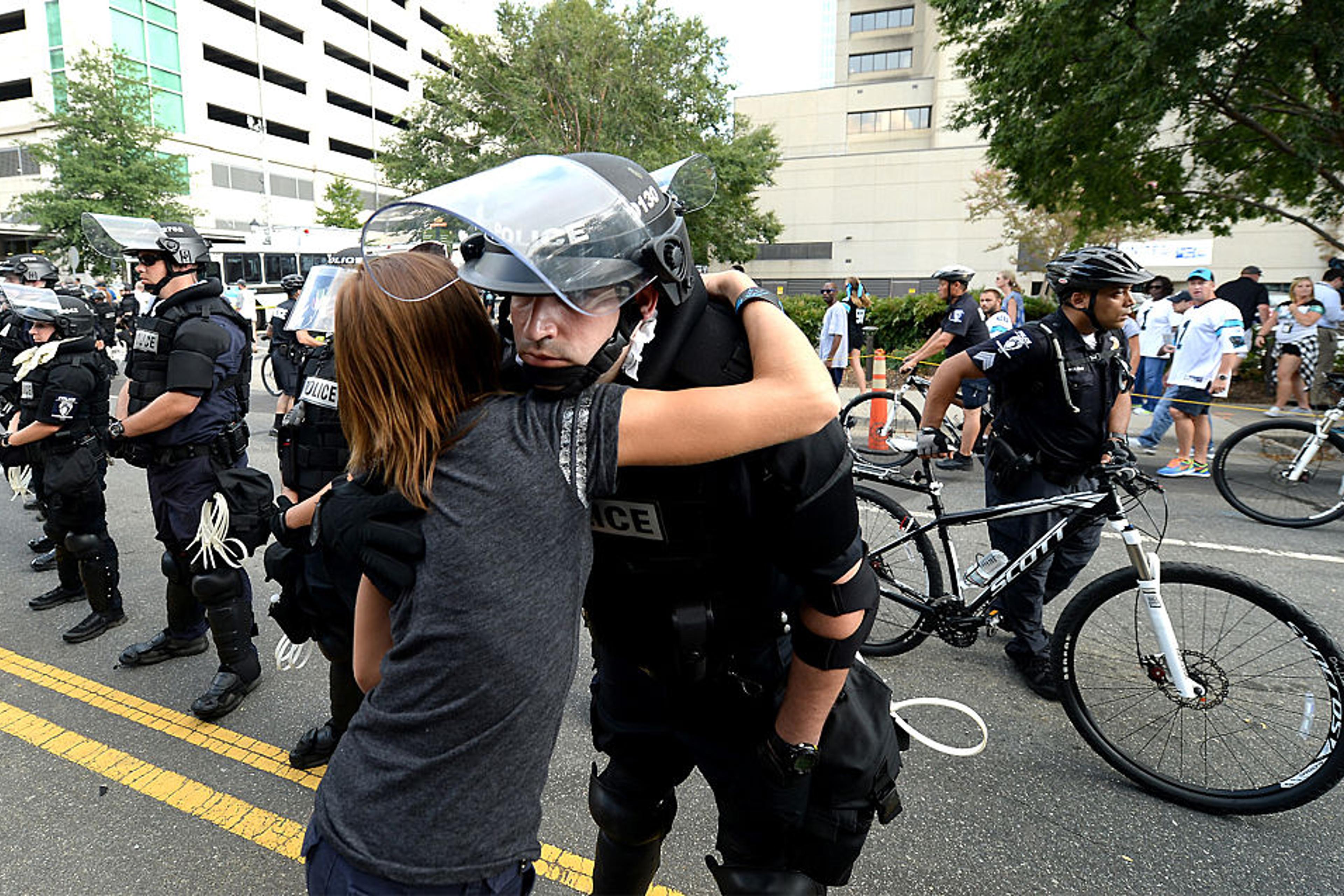 A woman hugs a police officer outside Bank of America Stadium on Sept. 25, 2016 in Charlotte, N.C.