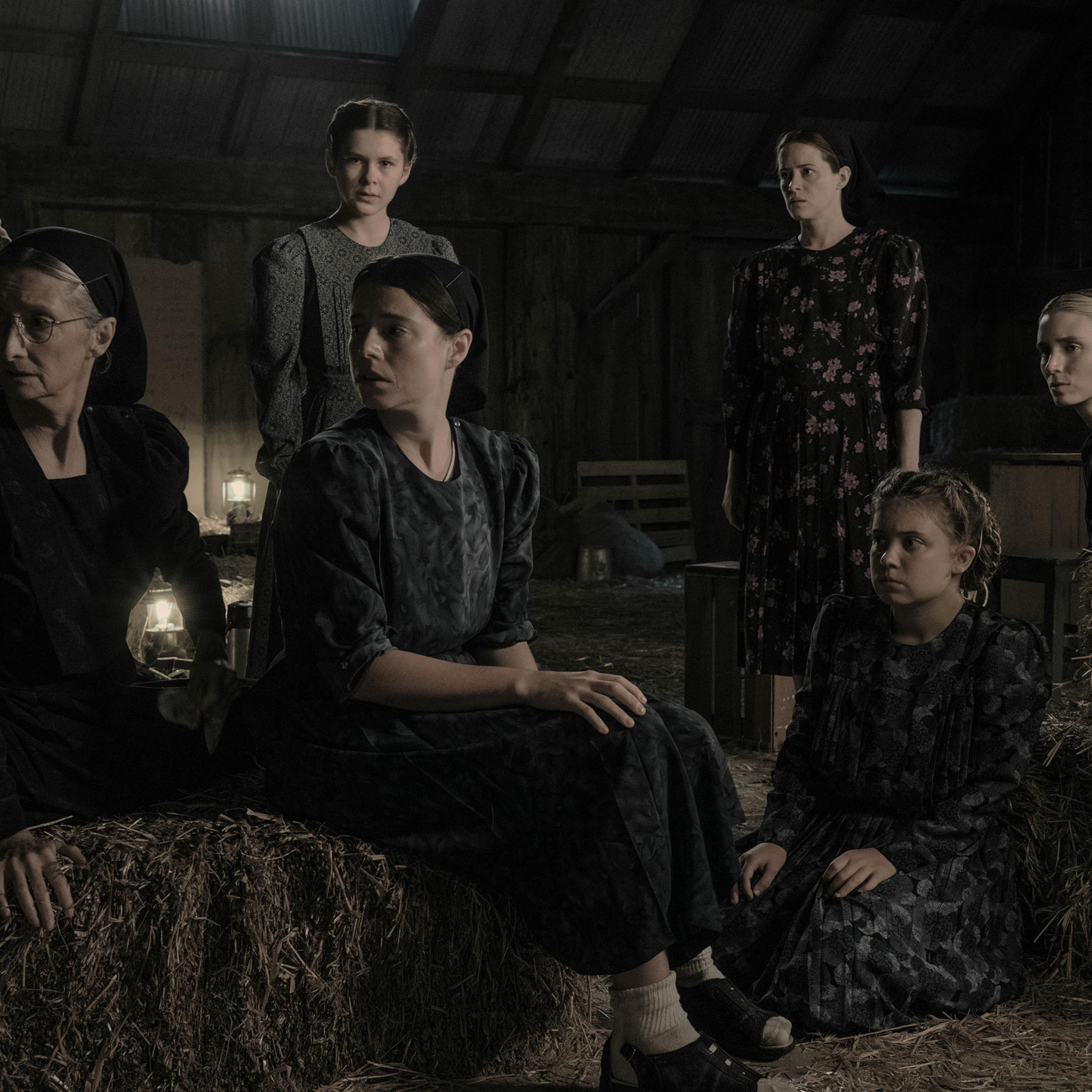 still from the film WOMEN TALKING, showing a group of Mennonite women wearing dresses and looking offscreen