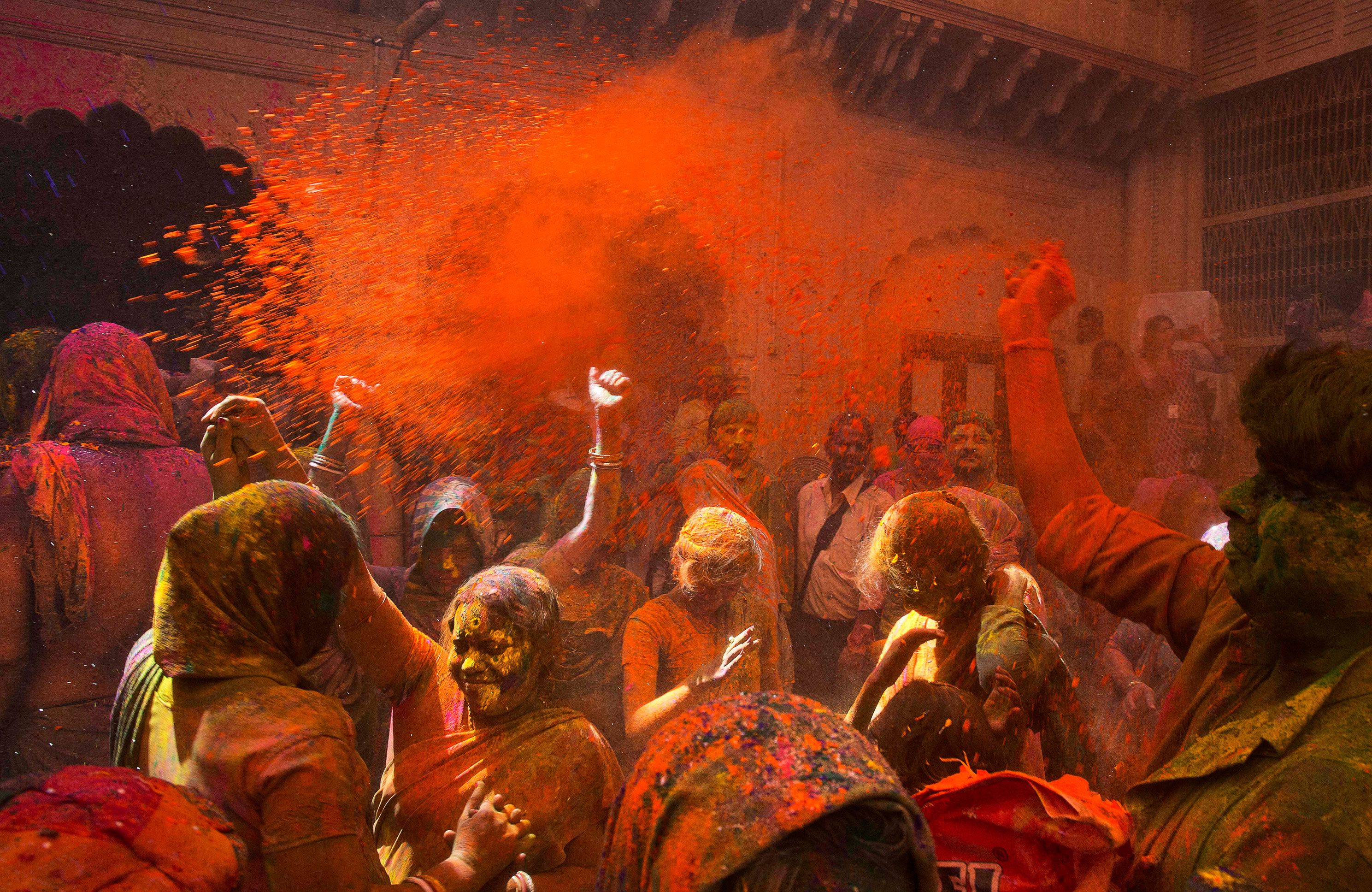 Locals and Indian Hindu widows throw flower petals and colored powder during Holi celebrations at the Gopinath temple, south-east of New Delhi, on March 21, 2016. 