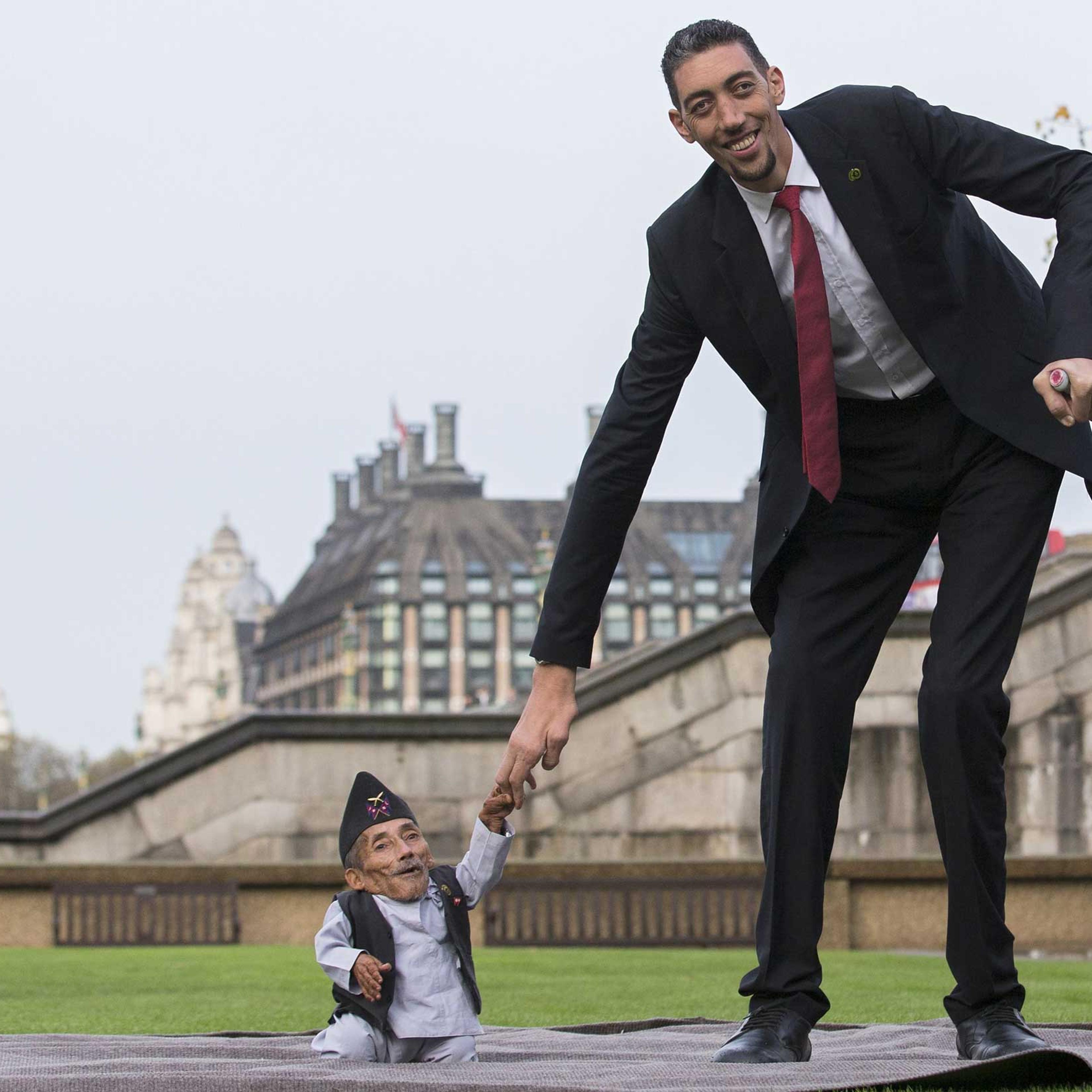 Chandra Bahadur Dangi, from Nepal, the shortest adult to have ever been verified by Guinness World Records, poses for pictures with the world's tallest man Sultan Kosen from Turkey, during a photocall in London on Nov. 13, 2014, to mark Guinness World Re