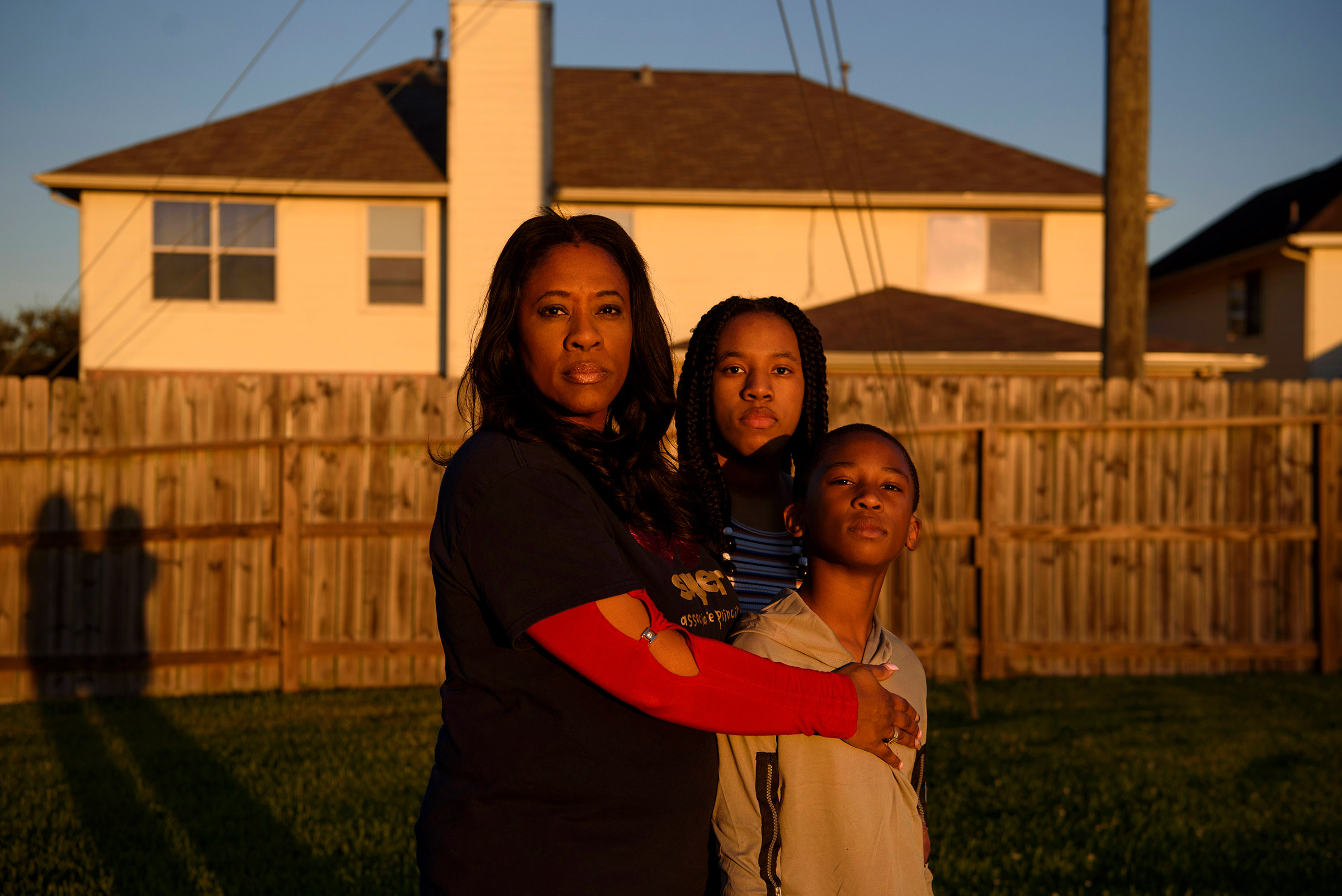 FRESNO, TX – OCTOBER 29, 2021: Adin James, 8, poses for a portrait alongside his mother, Ebony, 50, and his sister, Madison, 16, following the death of his father, Terrence James, who died after becoming ill with COVID-19, in Fresno, Texas.