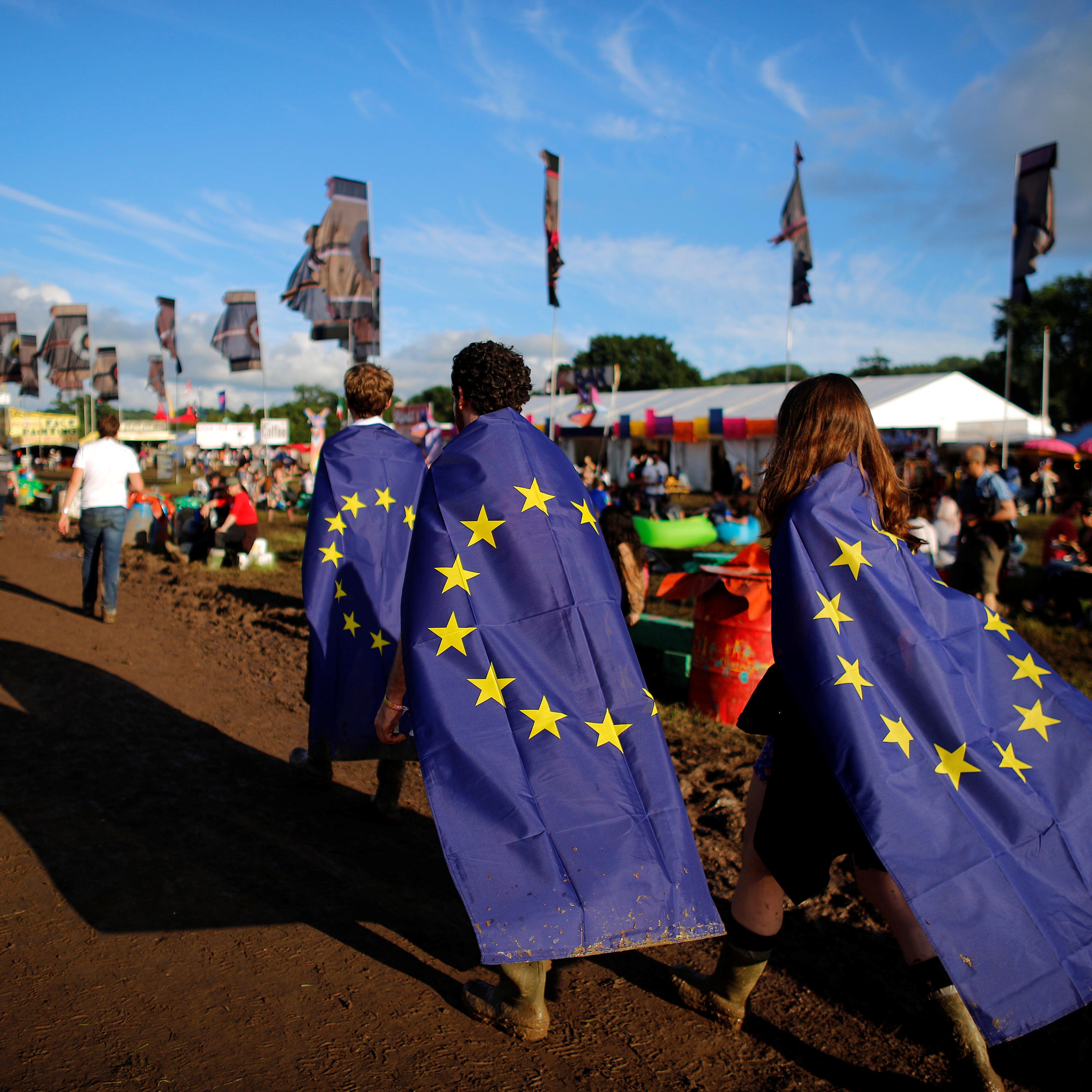 Revellers wrapped in European Union flags walk at Worthy Farm in Somerset during the Glastonbury Festival