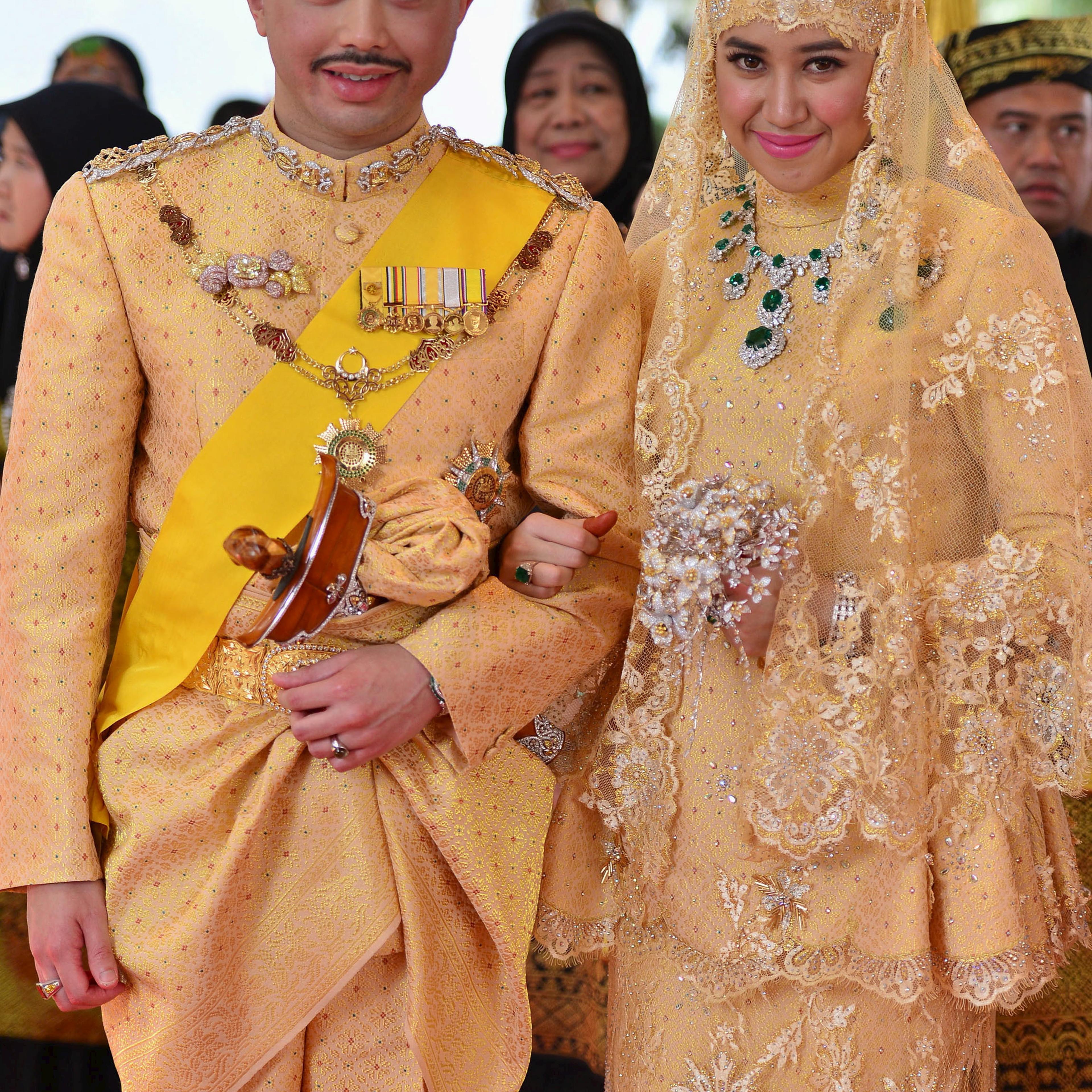 Brunei's newly wed royal couple, Prince Abdul Malik and Dayangku Raabi'atul 'Adawiyyah Pengiran Haji Bolkiah, pose for photographers after the enthronement ceremony at their wedding in the Nurul Iman Palace in Bandar Seri Begawan