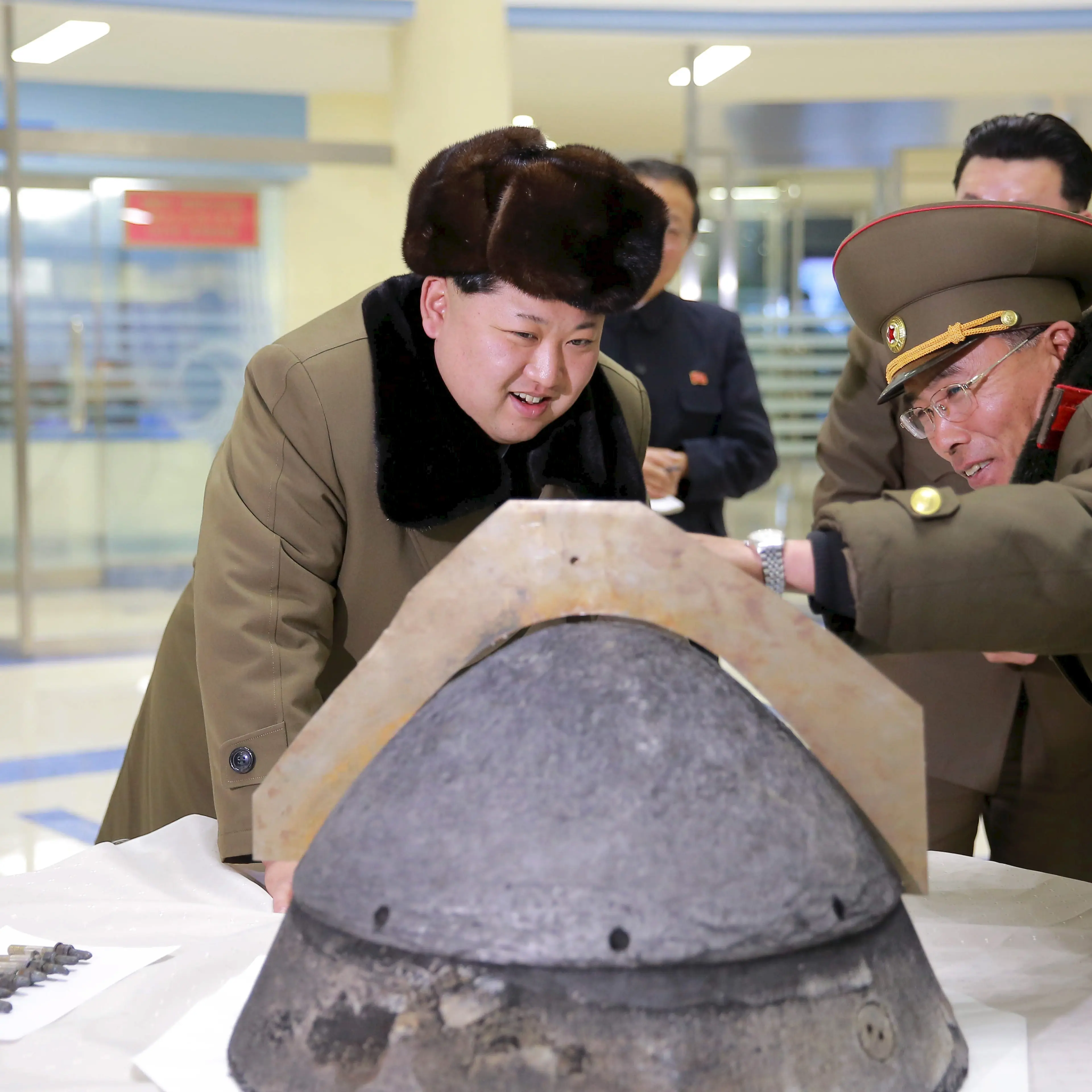 KCNA file picture shows North Korean leader Kim Jong Un looking at a rocket warhead tip after a simulated test of atmospheric re-entry of a ballistic missile