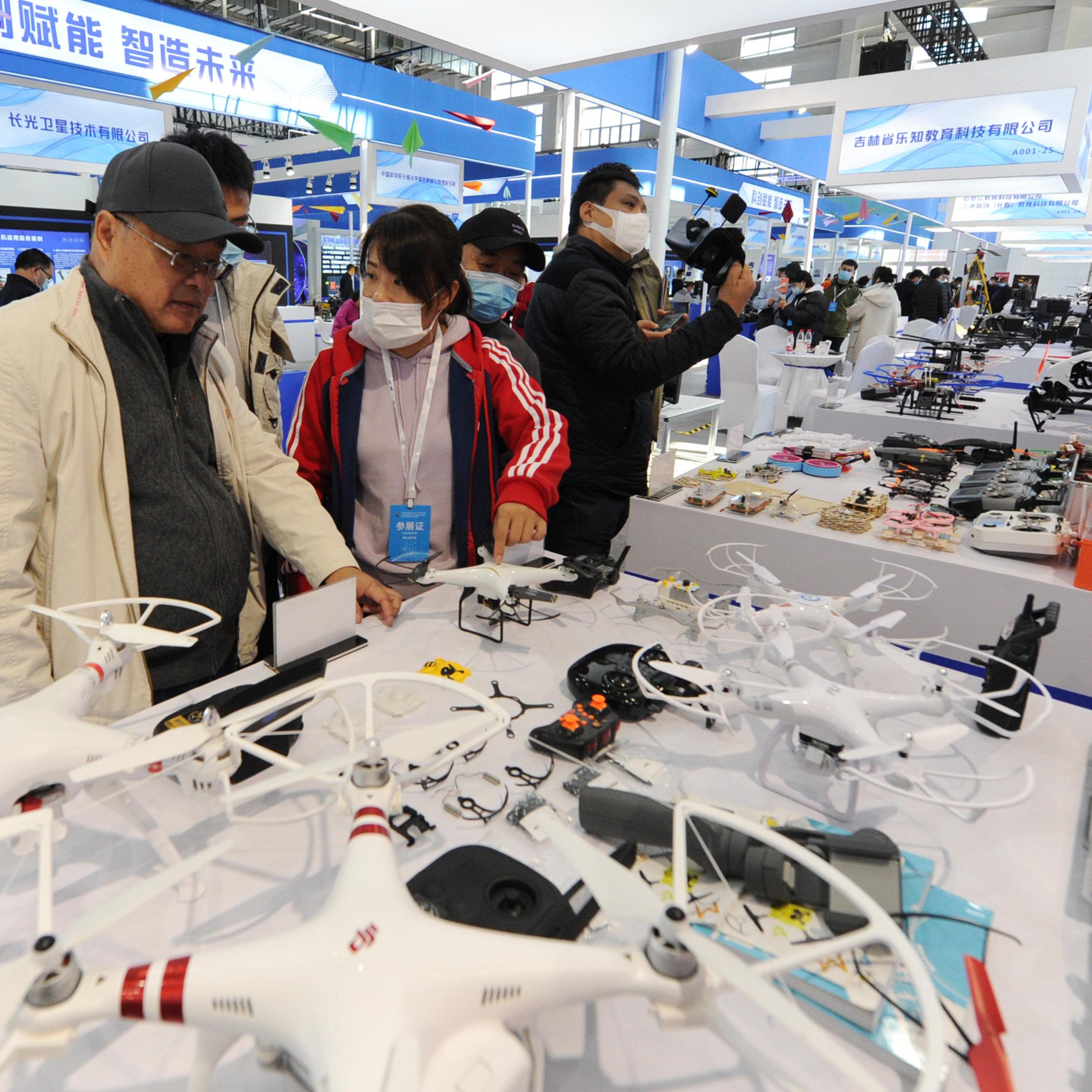 People look at drones at the DJI stand during the 2020 Changchun International UAV Industry Expo at CCIAFF Expo park on October 16, 2020 in Changchun, Jilin Province of China.