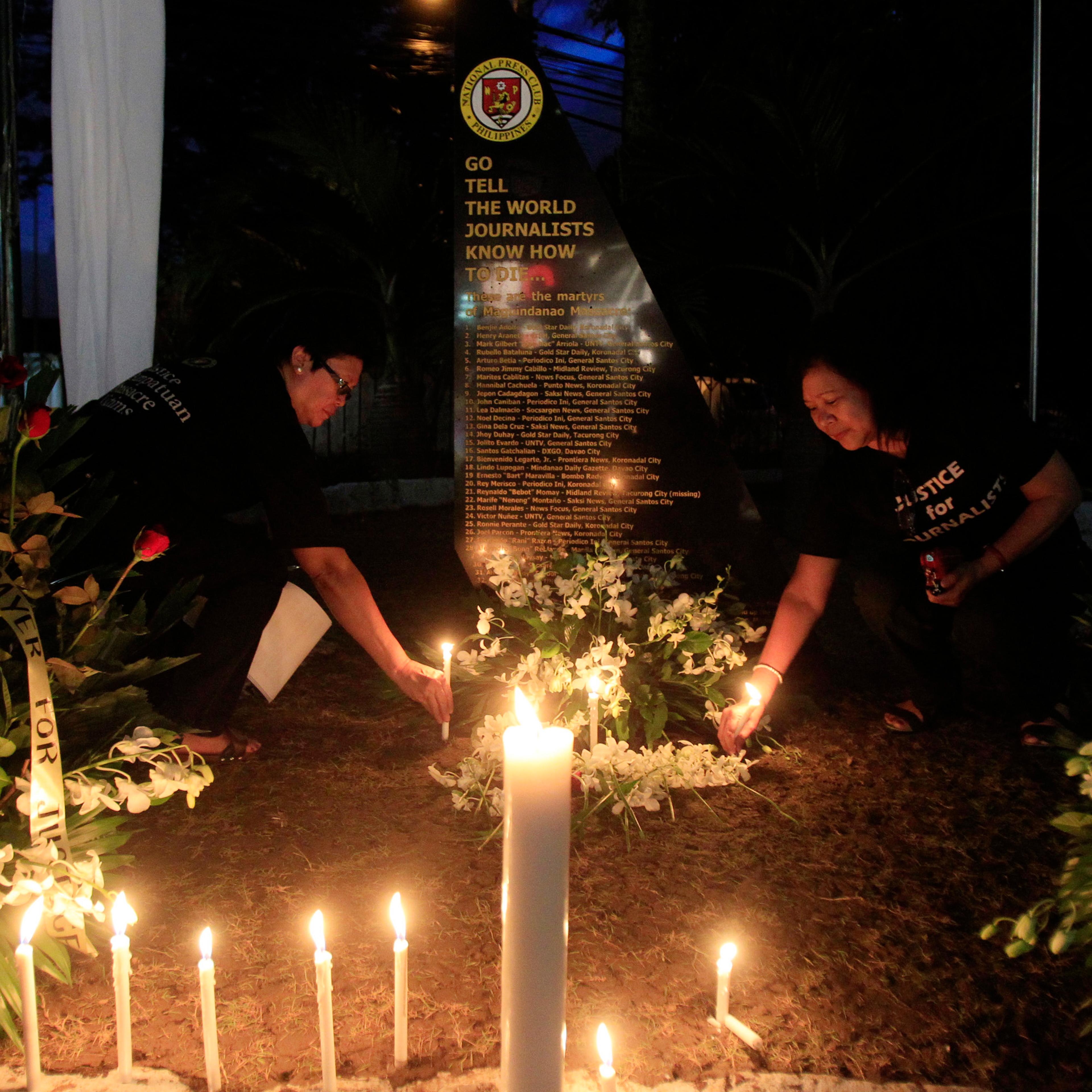 Filipino journalists light candles to commemorate the 2nd year anniversary of the "Maguindanao Massacre" at the National Press Club compound in Manila
