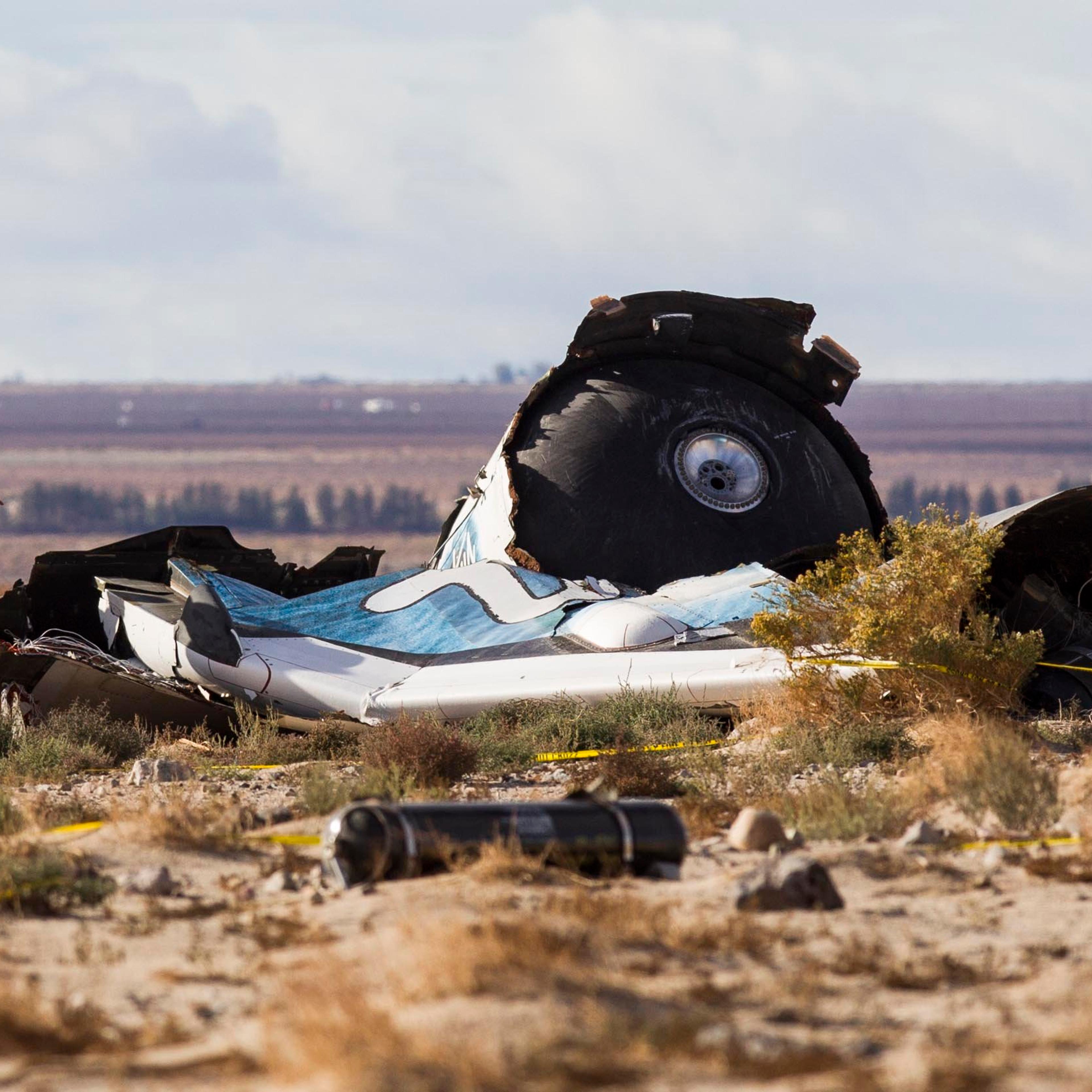 Law enforcement officers take a closer look at the wreckage near the site where a Virgin Galactic space tourism rocket, SpaceShipTwo, exploded and crashed in Mojave, Calif. on Nov 1, 2014.