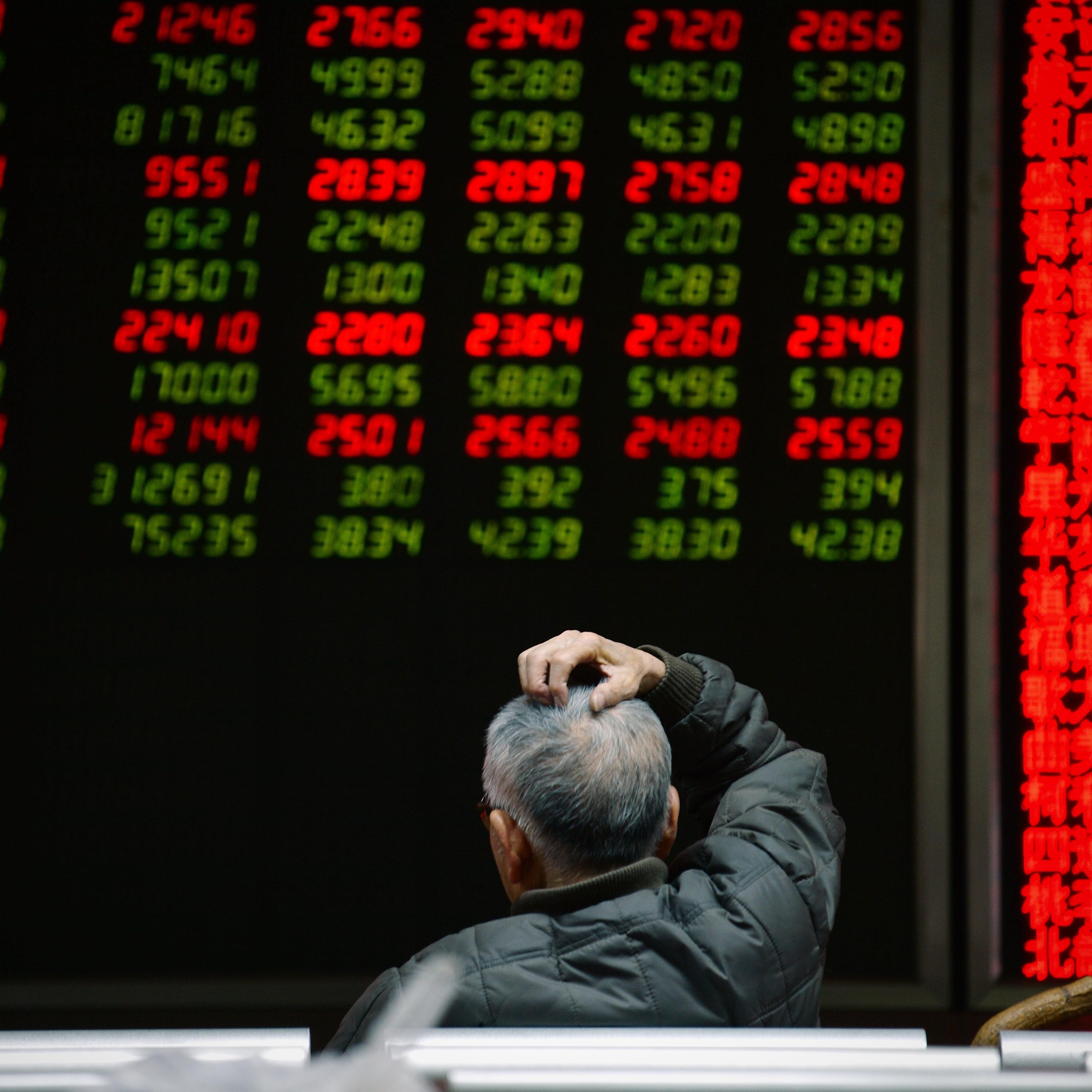 An investor looks at screens showing stock market movements at a securities company in Beijing on Jan. 14, 2016.