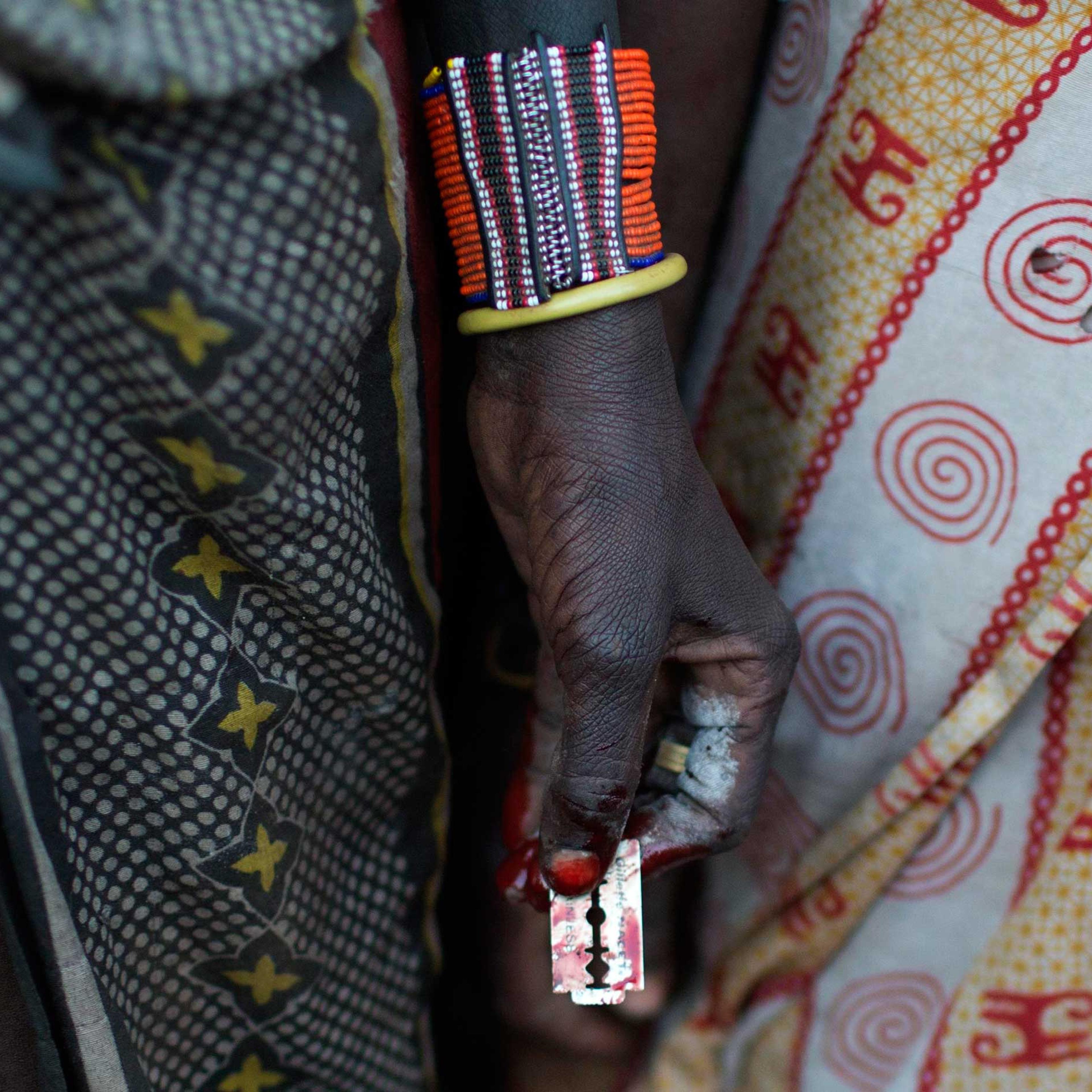 A Pokot woman holds a razor blade after performing a circumcision on four girls in a village about 80 kilometres from the town of Marigat in Baringo County, Kenya, Oct. 16, 2014.