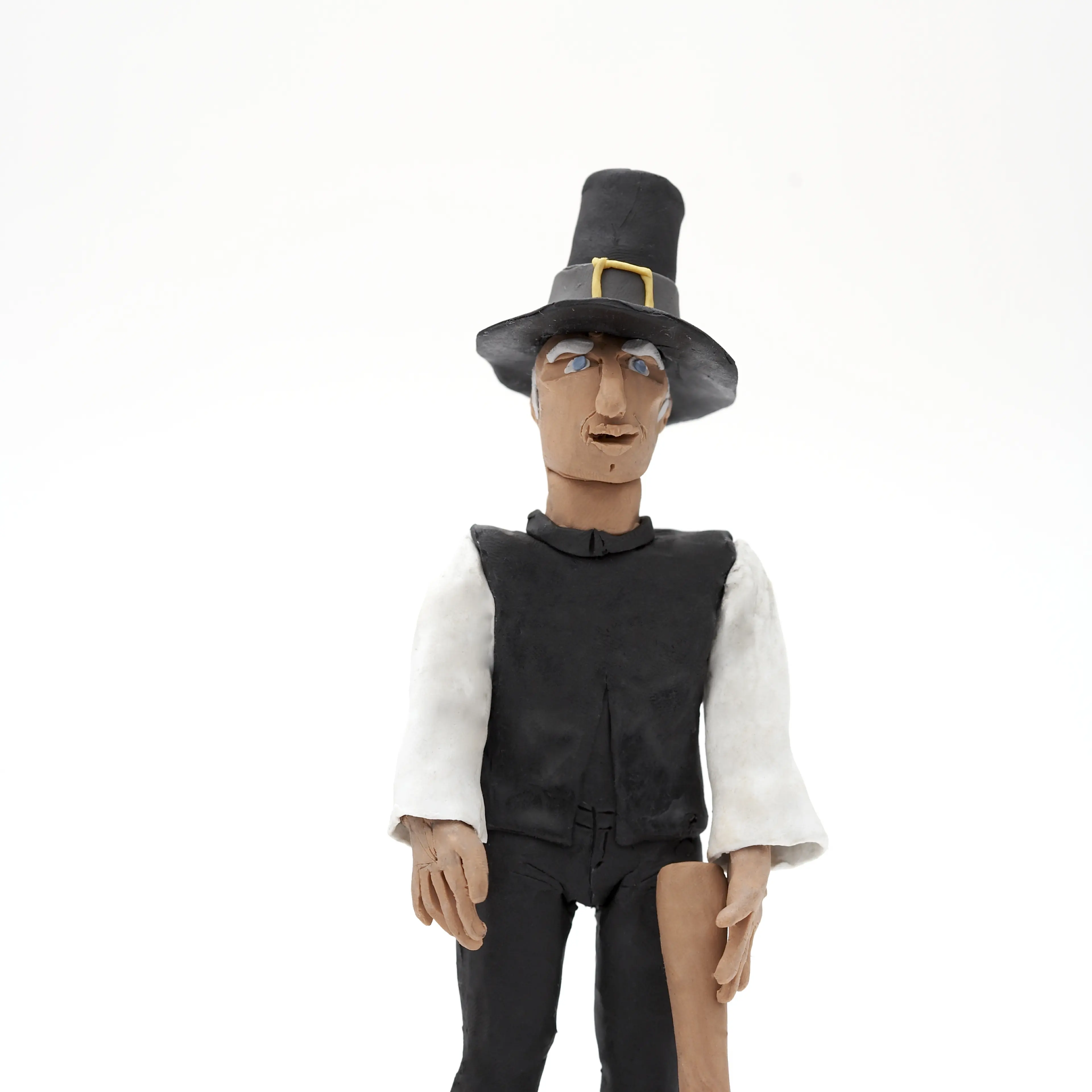 Clay model of Pilgrim figure with turkey and axe on a white background