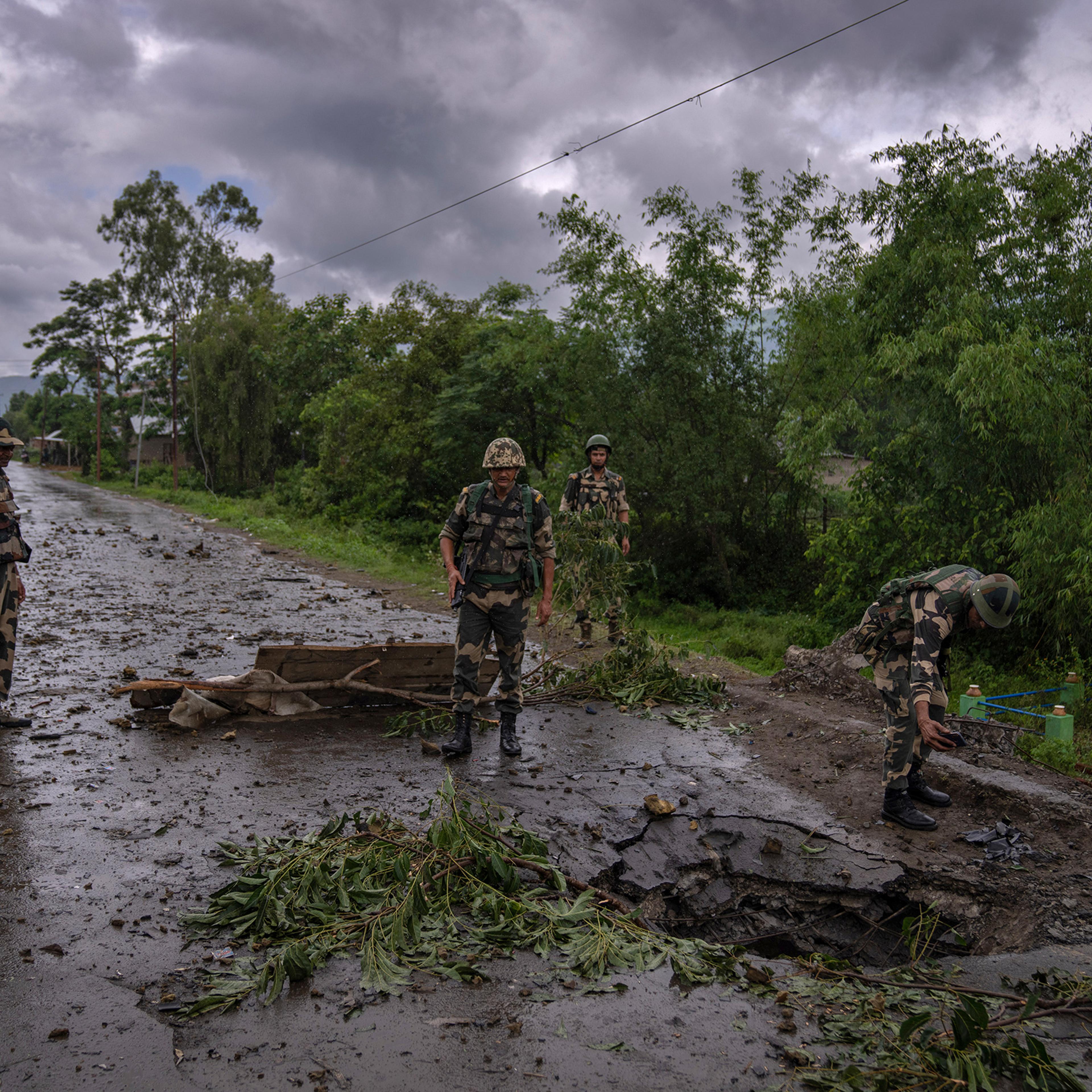 Indian paramilitary soldiers inspect the site of a car bomb explosion in Kwakta, some 50 kilometers from Imphal, capital of the northeastern Indian state of Manipur on June 22. Manipur is caught in a deadly conflict between two ethnic communities that have armed themselves and launched brutal attacks against one another. The clashes, which have left at least 120 dead by the authorities' conservative estimates, persist despite the army’s presence.