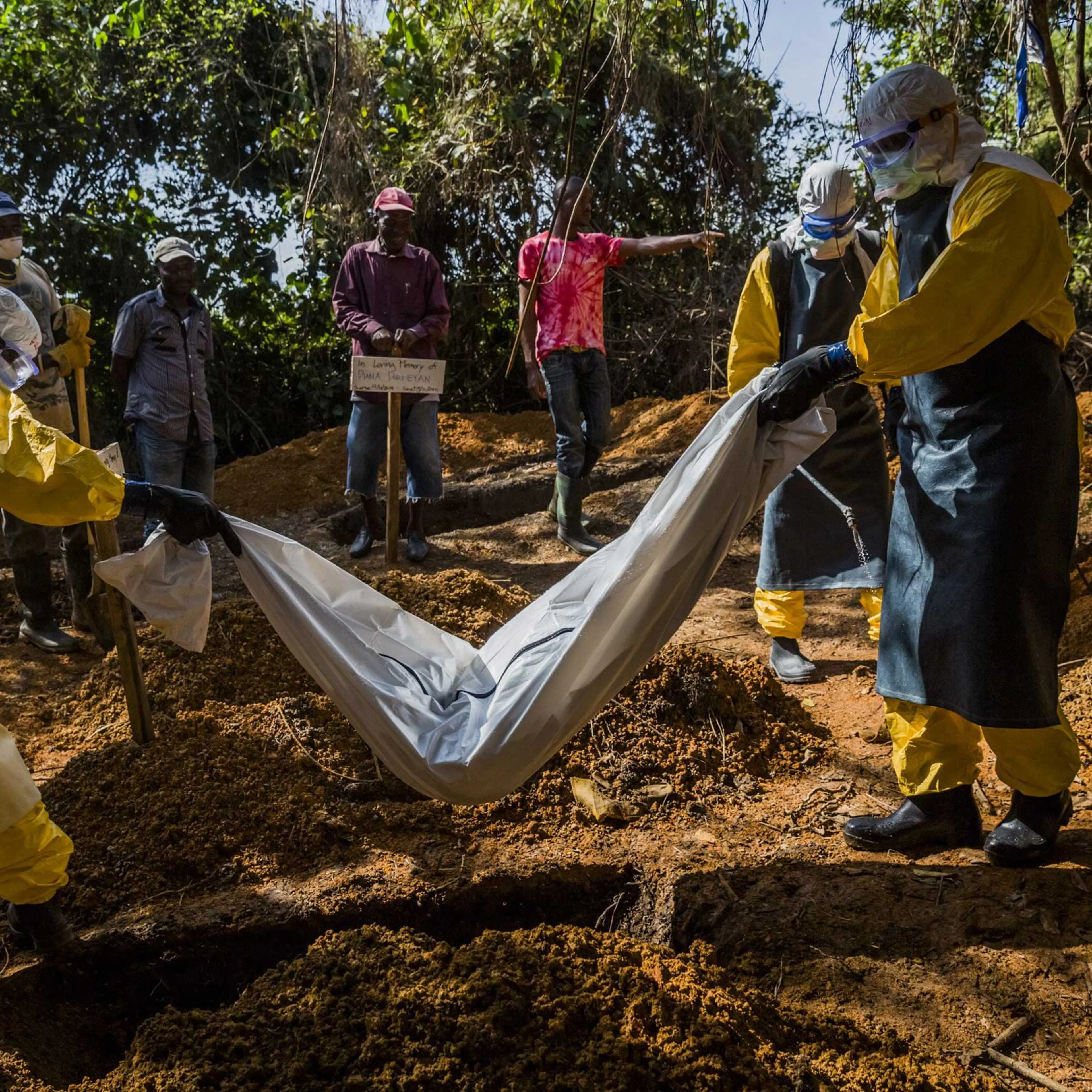 Members of a burial team wearing protective gear transfer the body of 4-day-old Diana Dormeyan, named for her mother who died shortly after giving birth, to a graveyard adjacent to the Bong County Ebola Treatment Unit near Gbarnga.