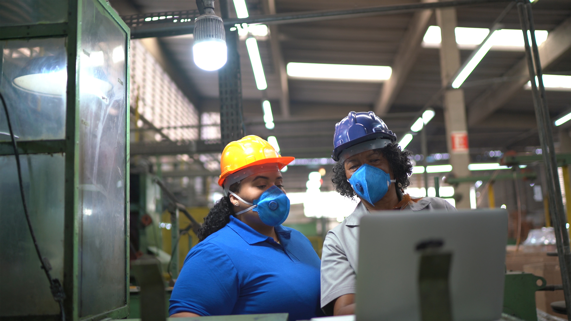 Factory workers doing an informal meeting and analyzing information on laptop
