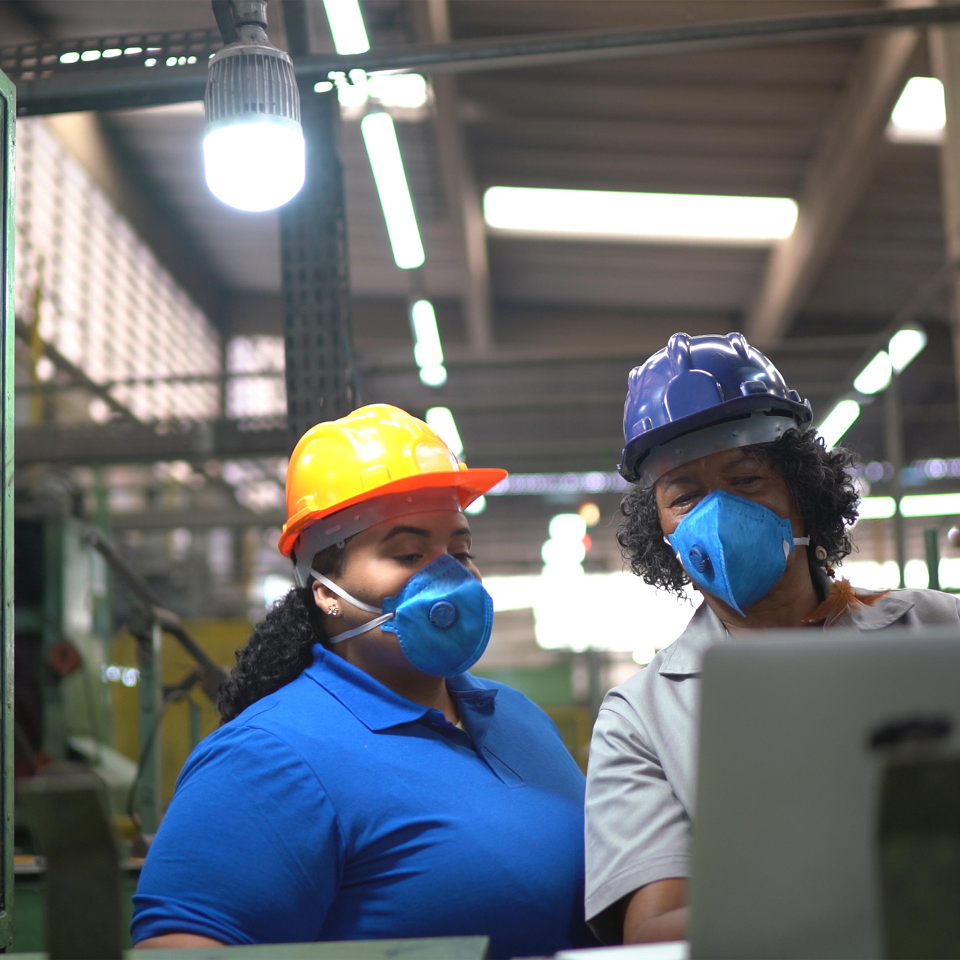 Factory workers doing an informal meeting and analyzing information on laptop