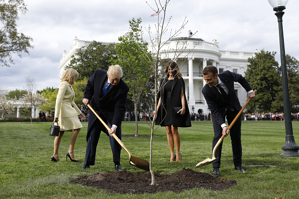Brigitte Macron, France's first lady, from left, U.S. President Donald Trump, U.S. First Lady Melania Trump, and Emmanuel Macron, France's president, participate in a tree planting on the South Lawn of the White House in Washington, D.C., U.S., on Monday