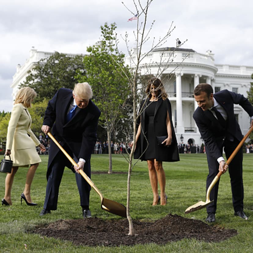 Brigitte Macron, France's first lady, from left, U.S. President Donald Trump, U.S. First Lady Melania Trump, and Emmanuel Macron, France's president, participate in a tree planting on the South Lawn of the White House in Washington, D.C., U.S., on Monday
