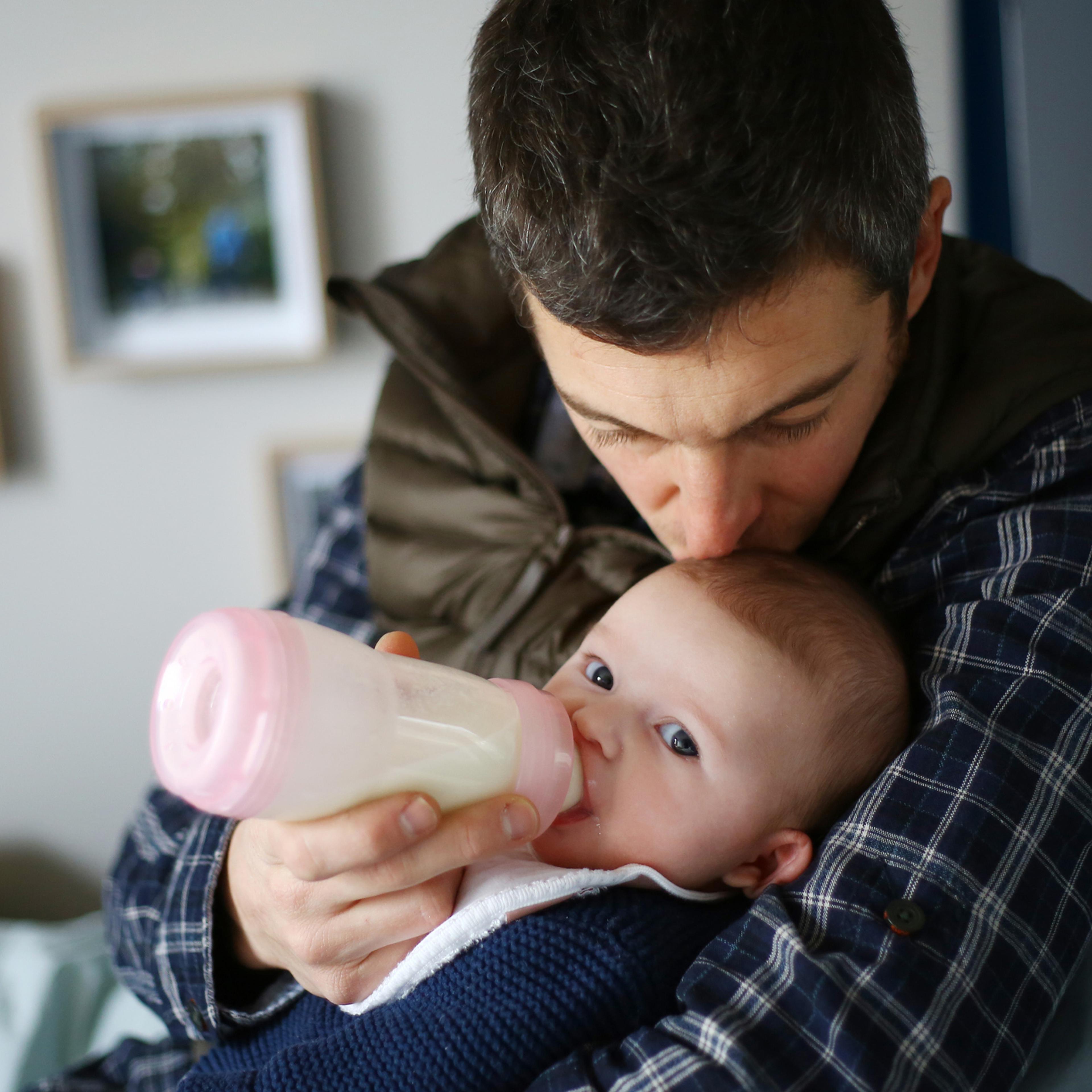 Father feeding baby with bottle