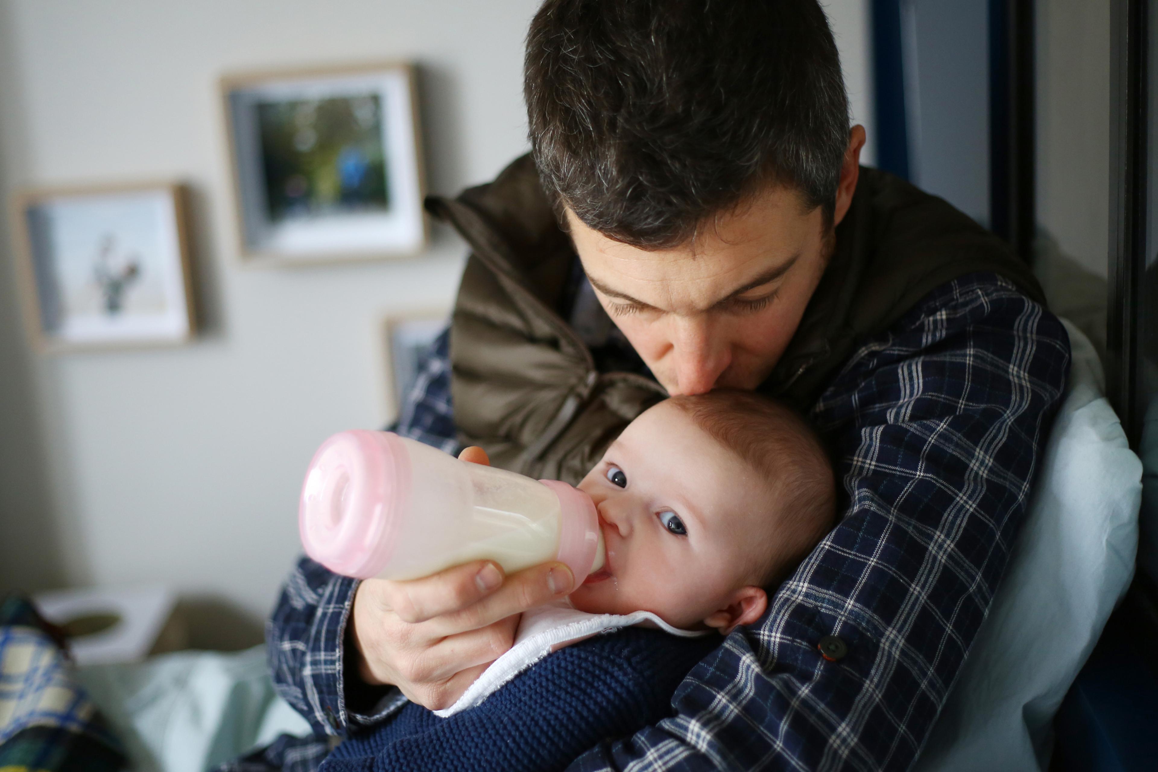 Father feeding baby with bottle