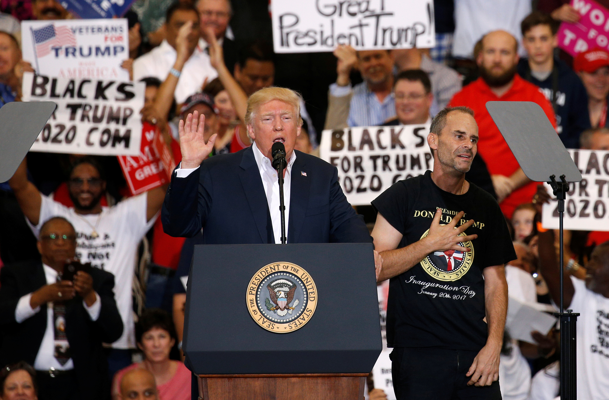 Trump holds a supporter invited onstage by U.S. President Donald Trump puts his hand to his chest during a "Make America Great Again" rally at Orlando Melbourne International Airport in Melbourne, Florida, U.S. February 18, 2017. REUTERS/Kevin Lamarque -