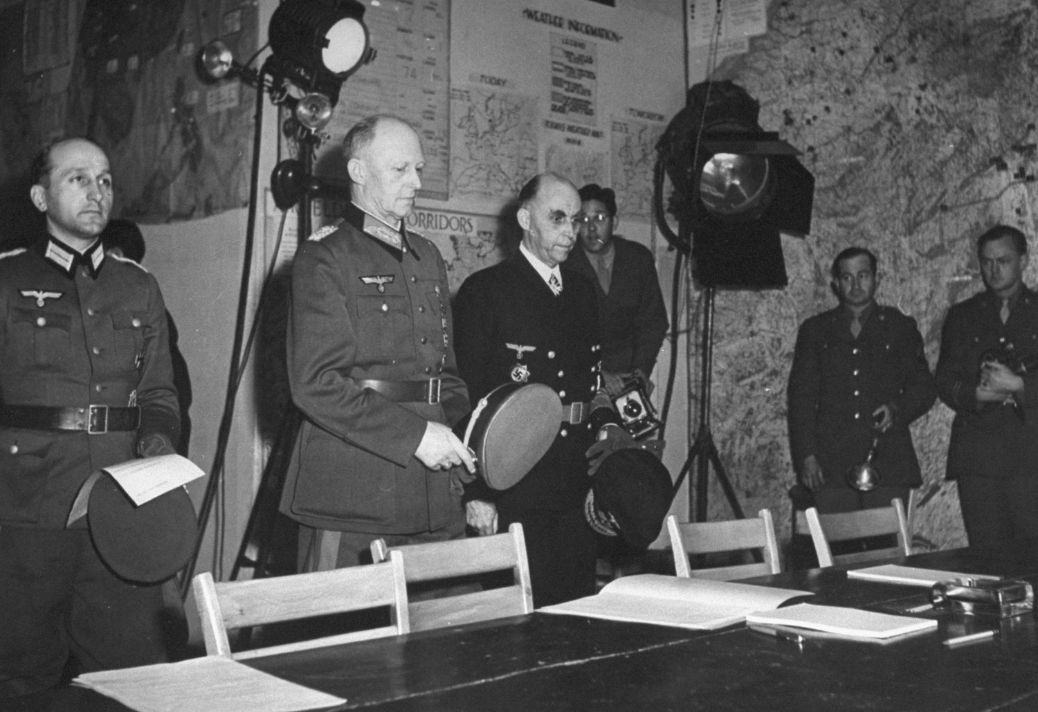The Germans, Major [Wilhelm] Oxenius, Col. General [Alfred] Jodl, Admiral General [Hans-Georg] von Friedeberg march stiffly in under floodlights at 2:39 a.m. Monday, May 7. Von Friedeberg was coolest of three.
